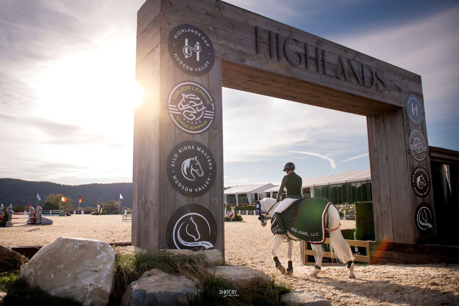 A Highland Brewing Company sign illuminated at dusk with a glowing sunset in the background.