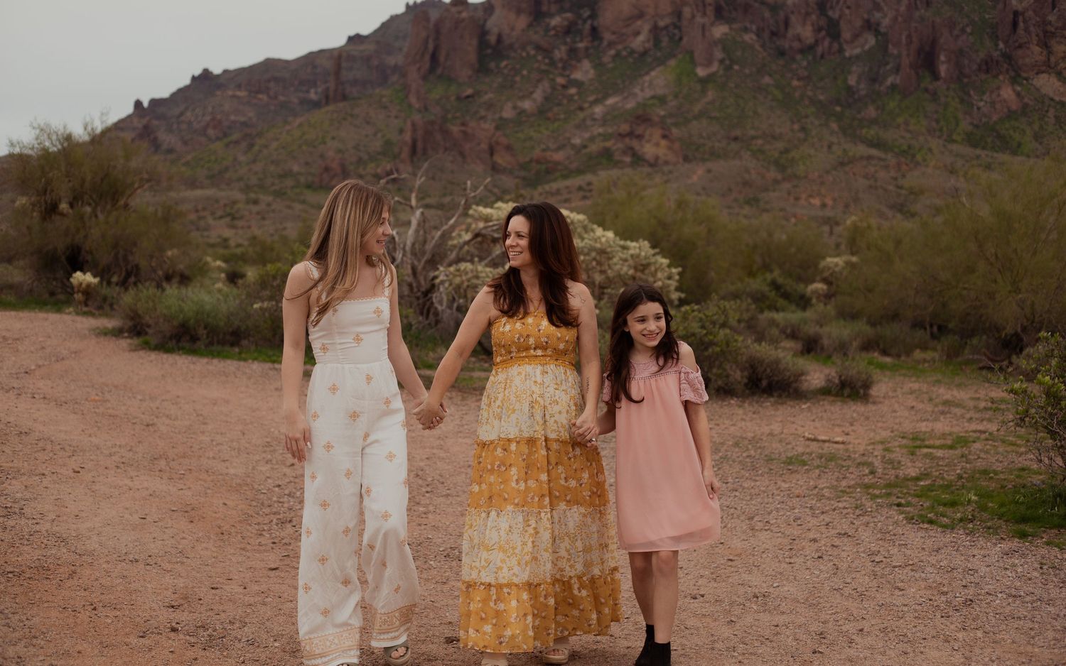 Family of three walking through desert landscape in Phoenix AZ