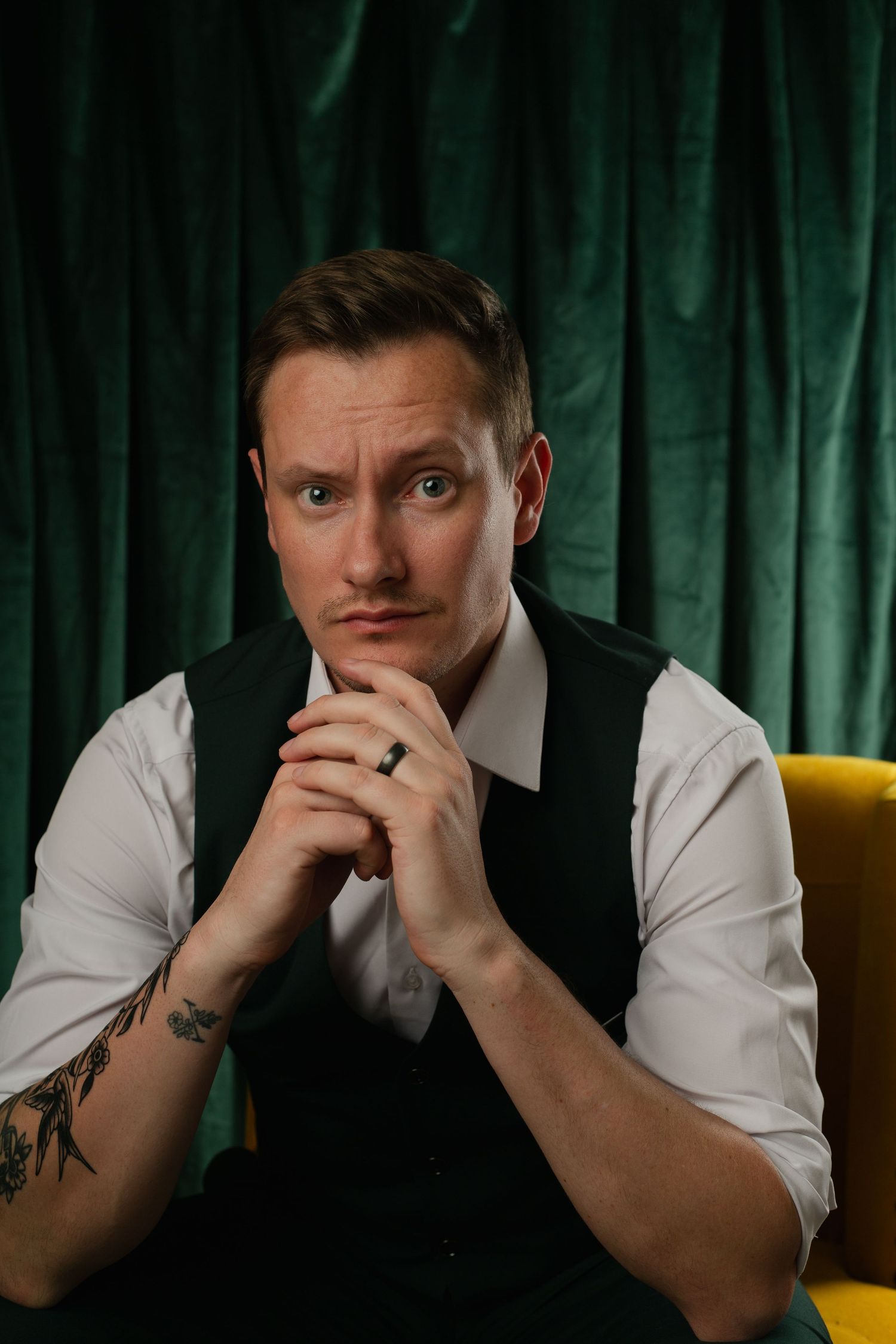 Male posing in dramatic studio portrait with colorful curtains in Phoenix AZ.