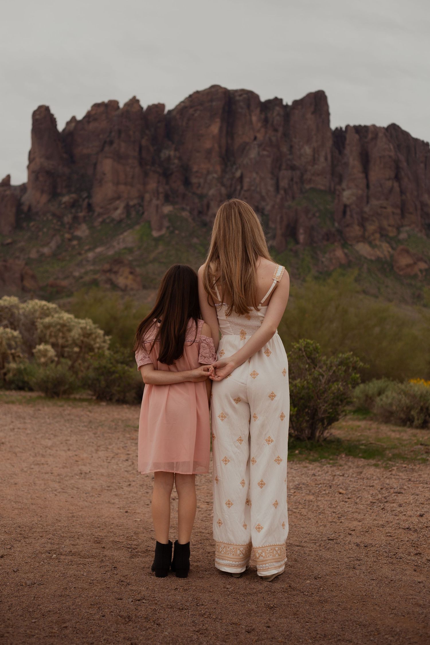 Sisters hugging in desert landscape in Phoenix AZ
