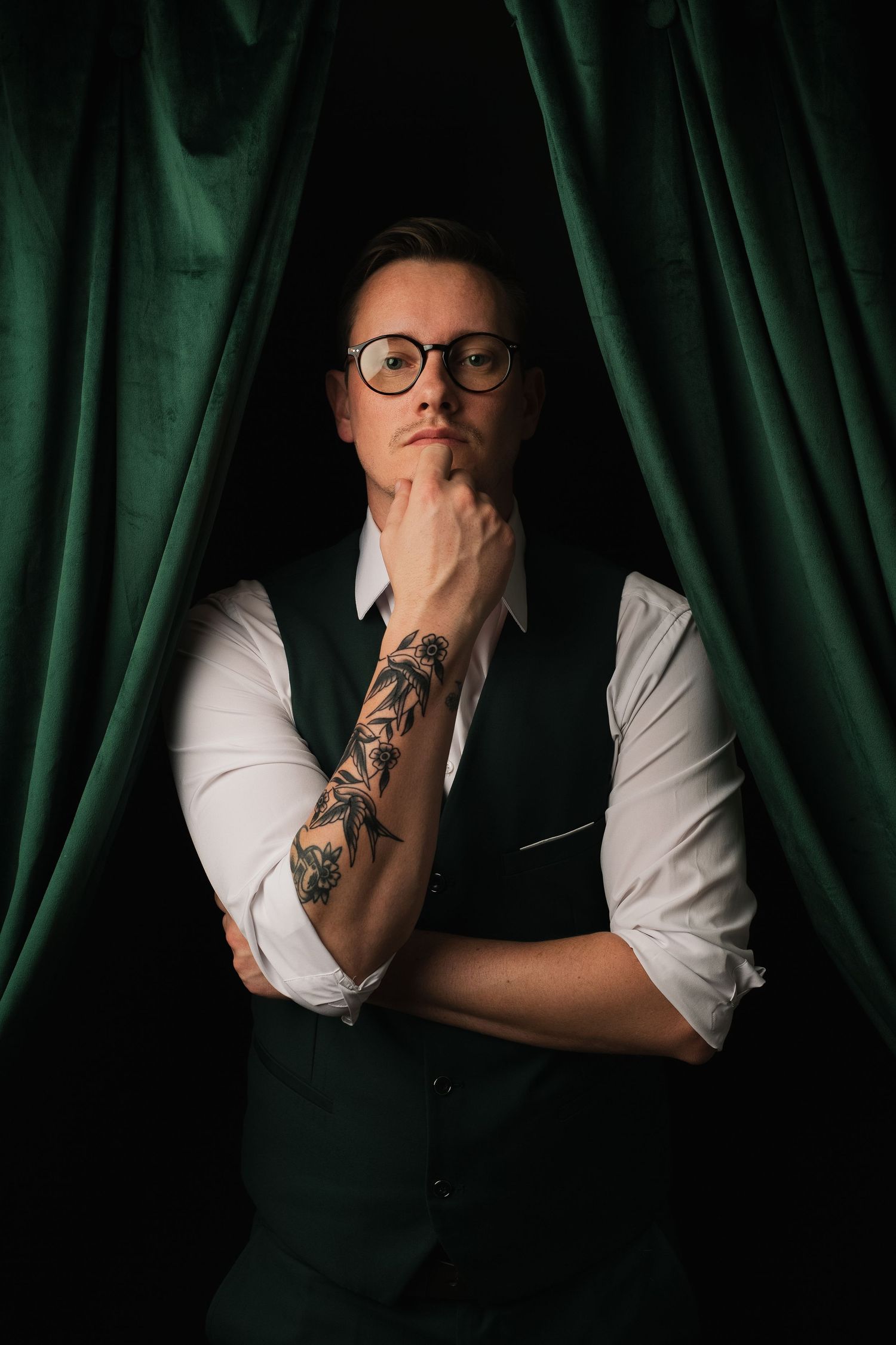 Male posing in dramatic studio portrait with colorful curtains in Phoenix AZ.