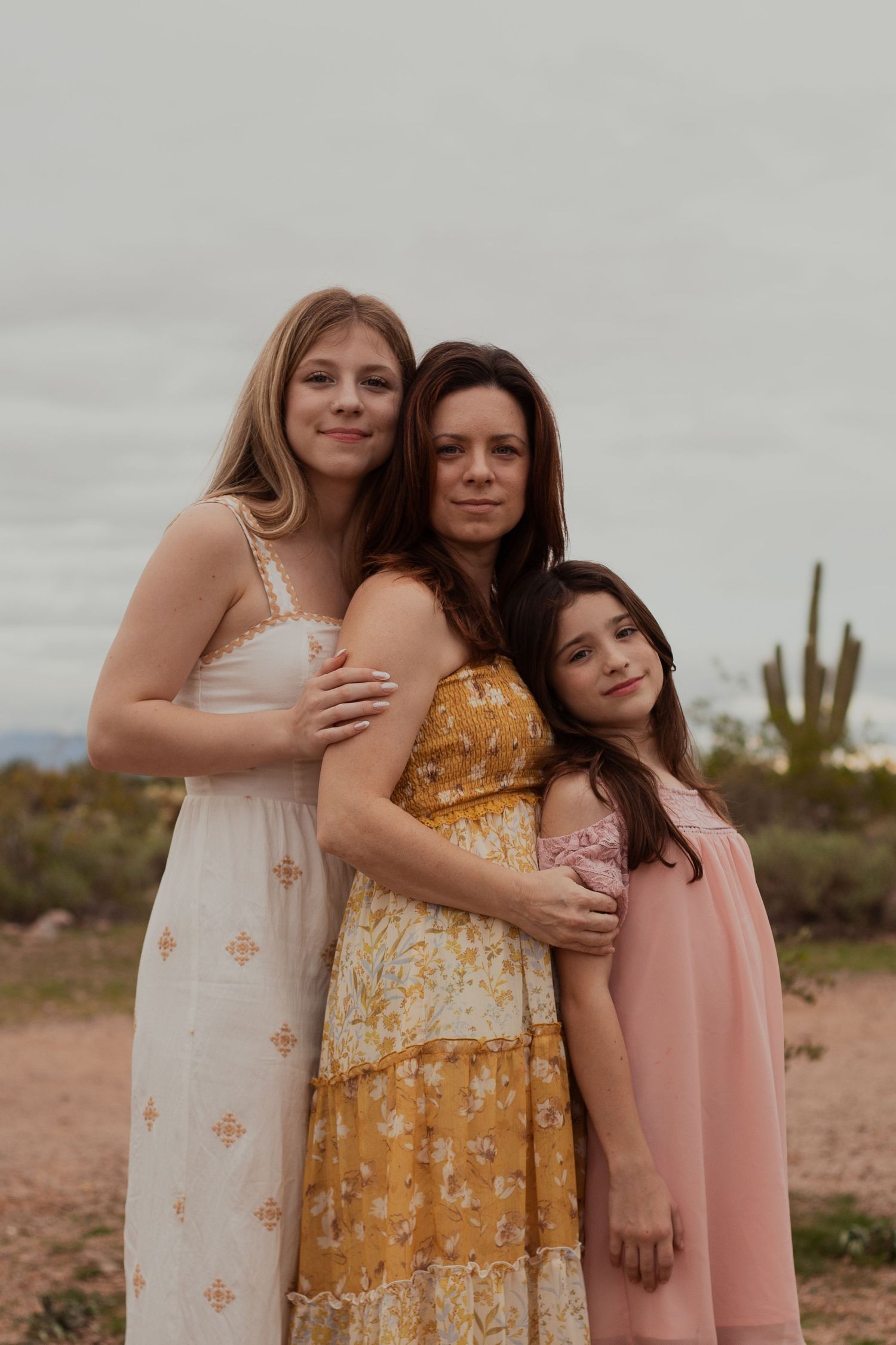 Family of three posing in desert landscape in Phoenix AZ