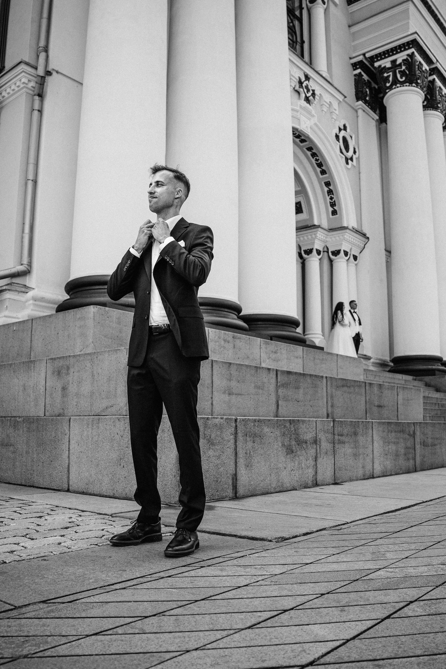 Jaunasis  kostiume stovi prieš Kauno Soborą