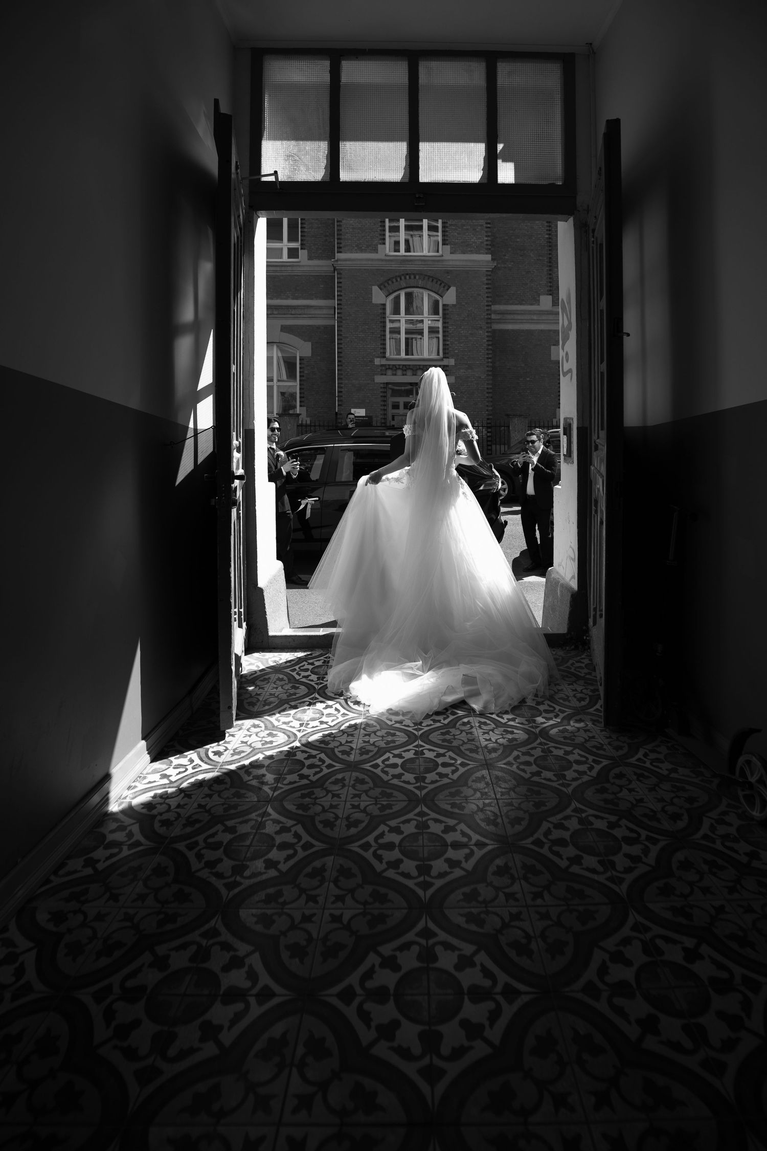 Dramatic black and white corridor shot with wedding dress silhouette.