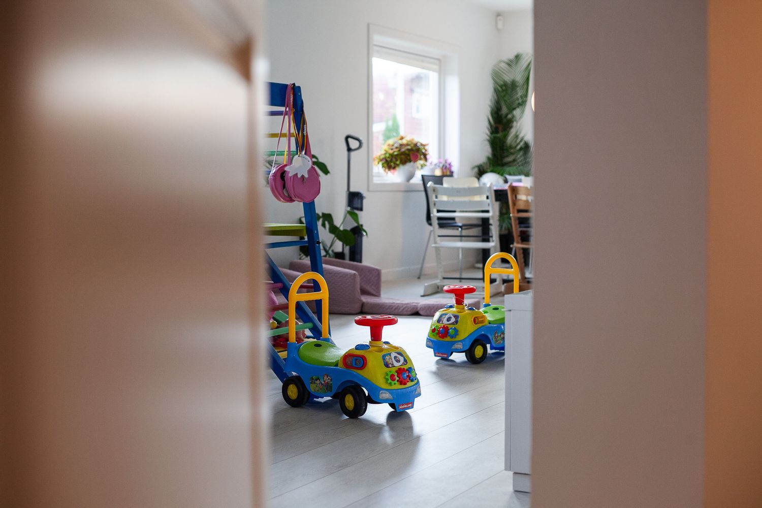 Colorful toy ride-on cars lined up in a bright indoor space.