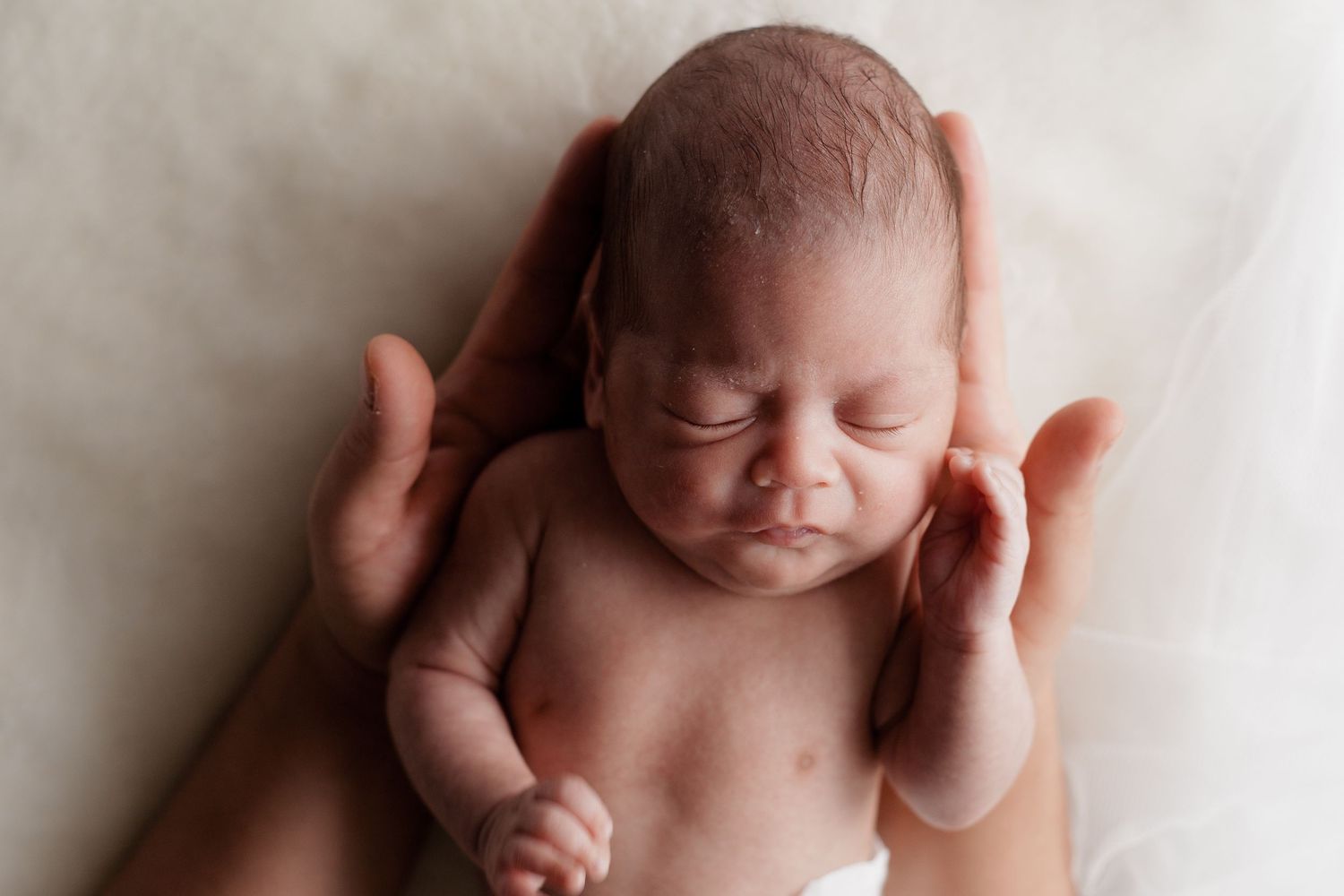Peaceful newborn portrait series showing delicate features against white backdrop.