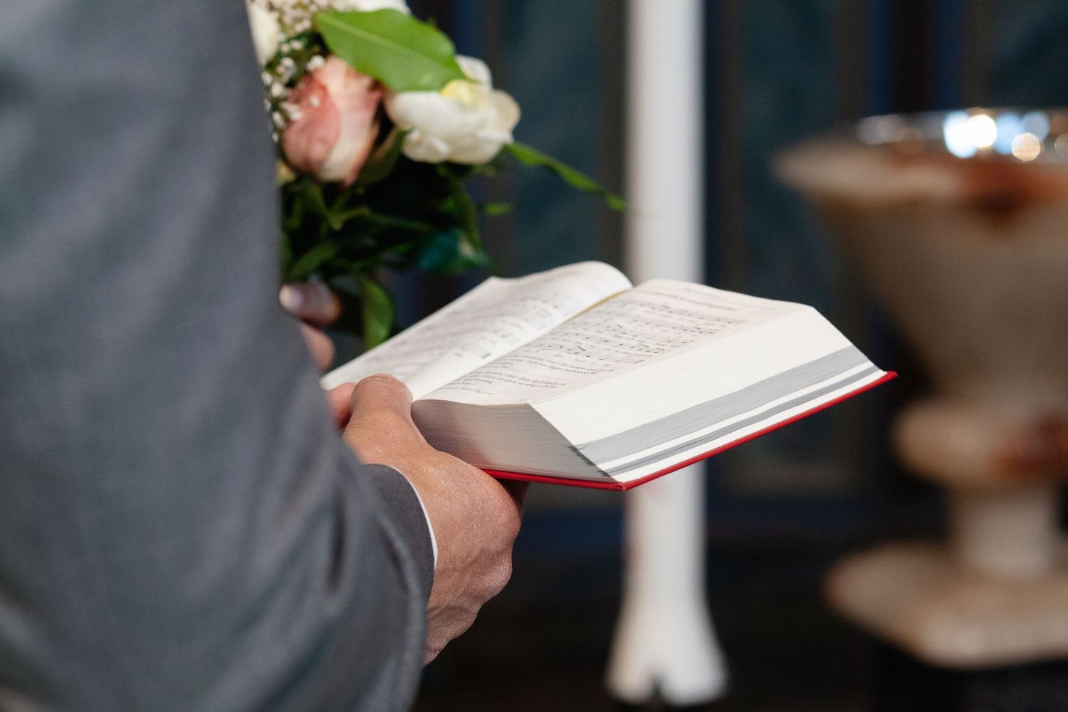 Close-up shots of white roses and ceremony details including a book or program.
