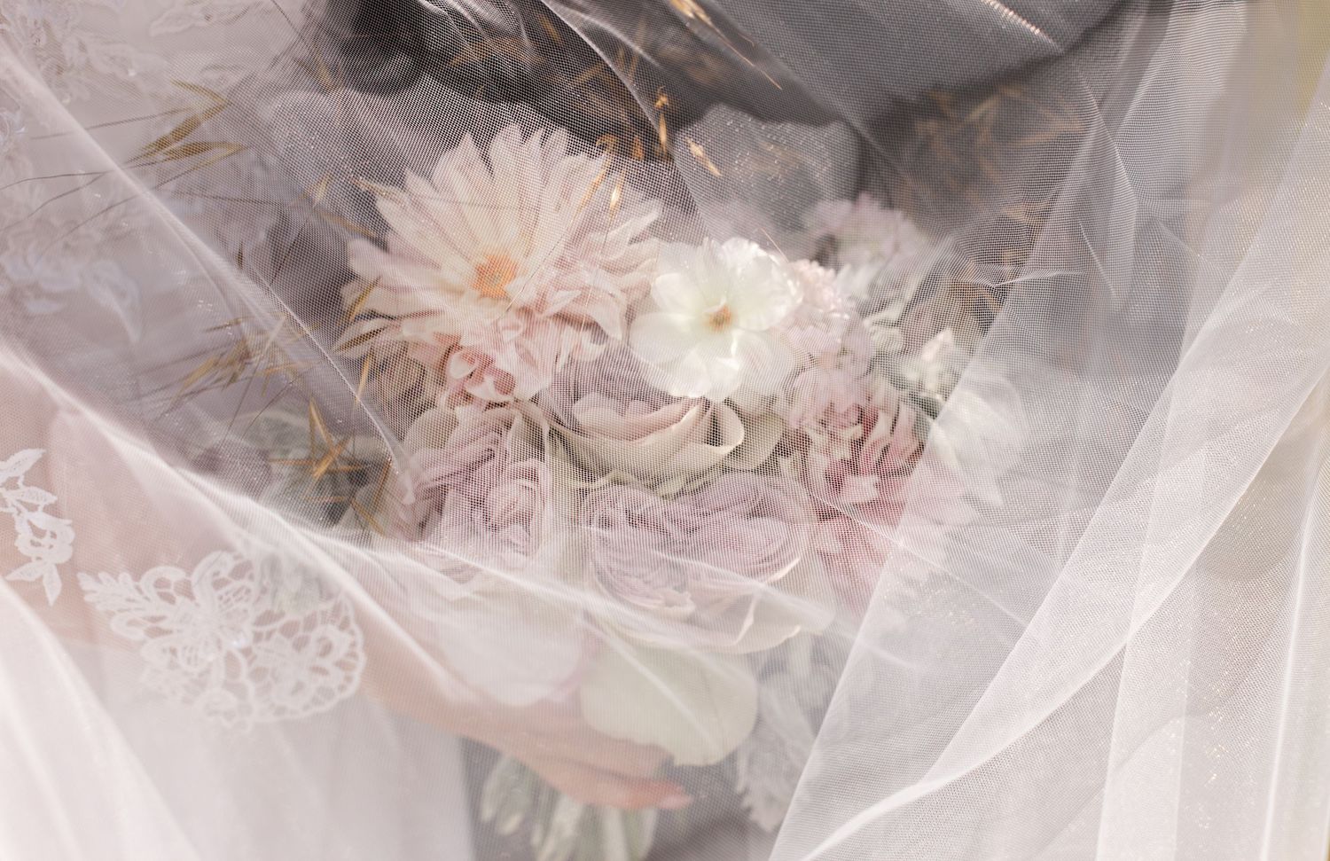 Ethereal close-up of delicate wedding details through sheer fabric creating a dreamy effect.