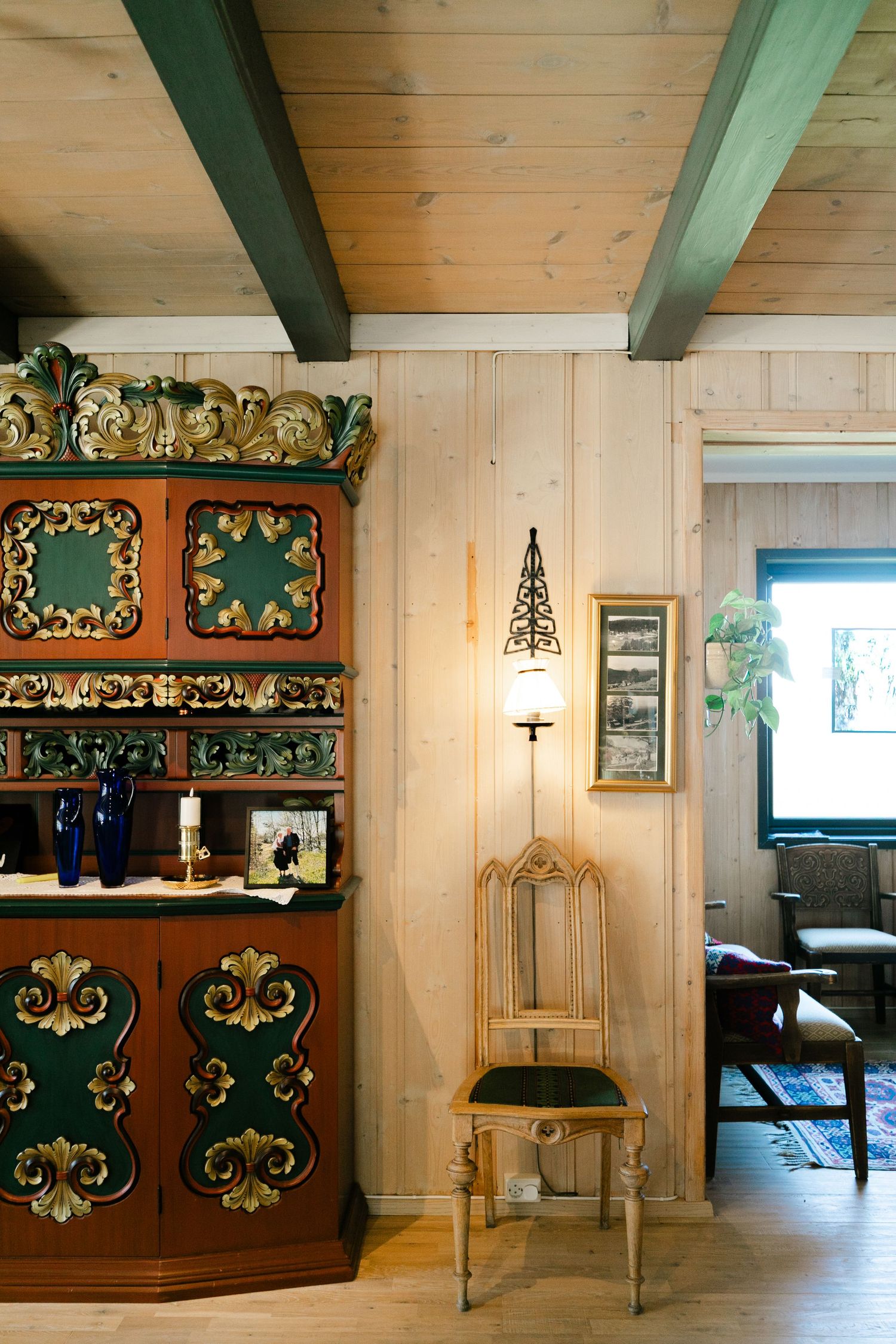 Interior room with green beams and decorative wooden furniture featuring ornate painted designs.