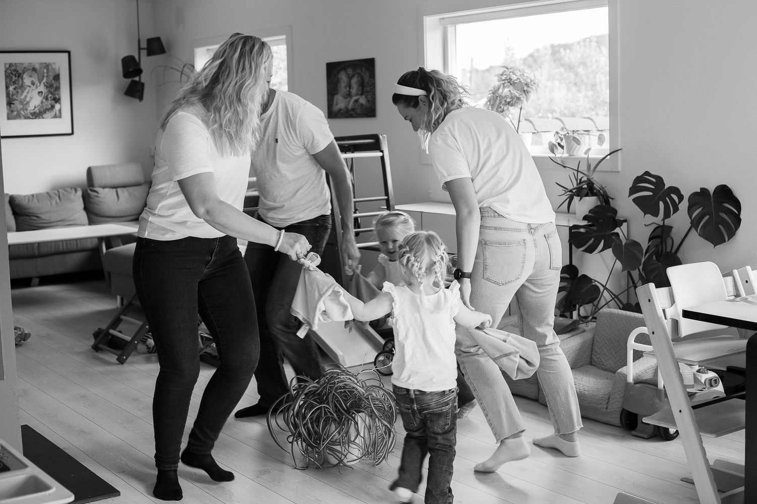 A group of people dancing together in a living room during a casual gathering.