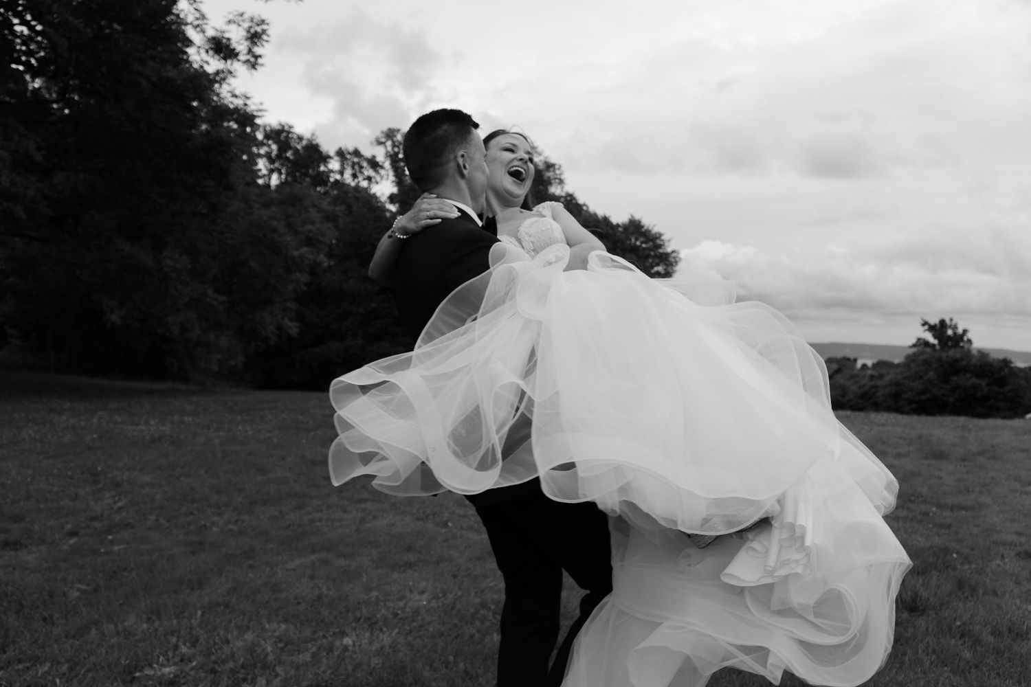 Romantic black and white photos of a couple dancing in a meadow.