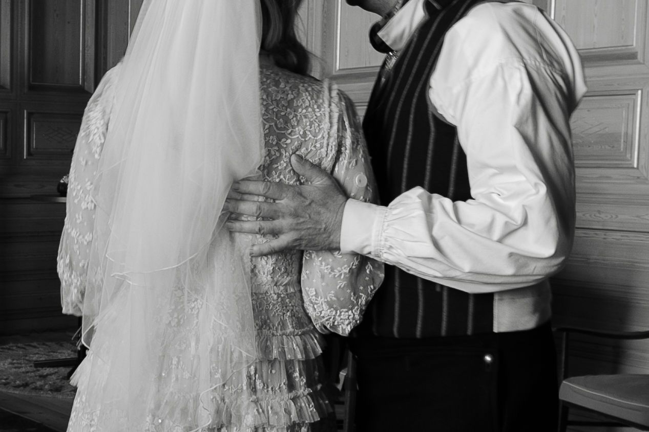 Wedding ceremony preparation showing elegant white dress details in a historic room.