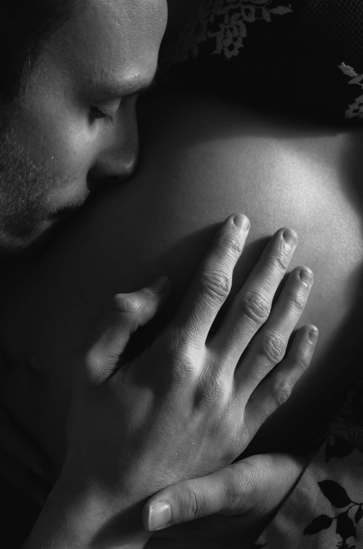 Close-up black and white photo of hands creating dramatic shadows and light.