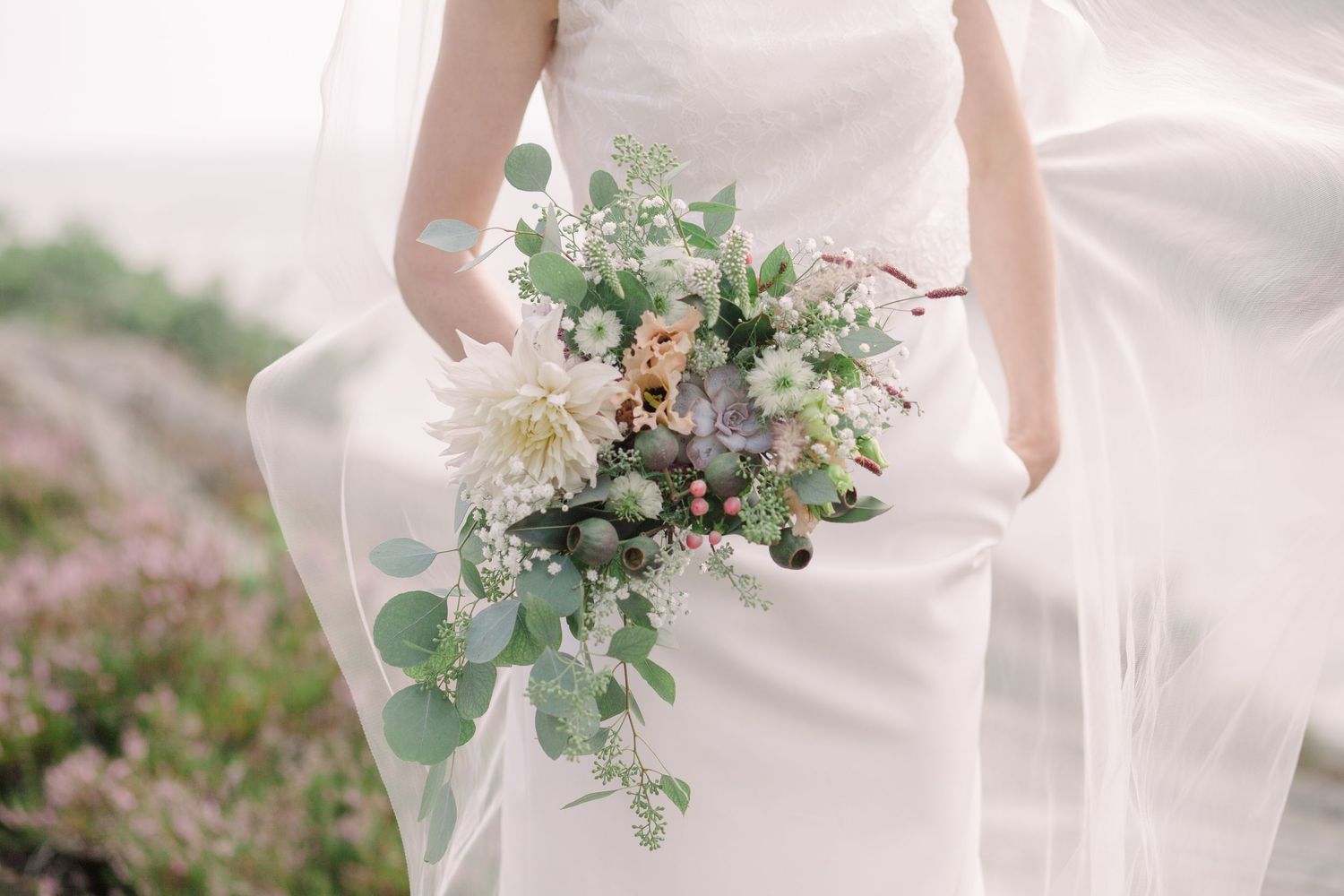 Elegant bridal bouquet with white flowers and eucalyptus leaves.
