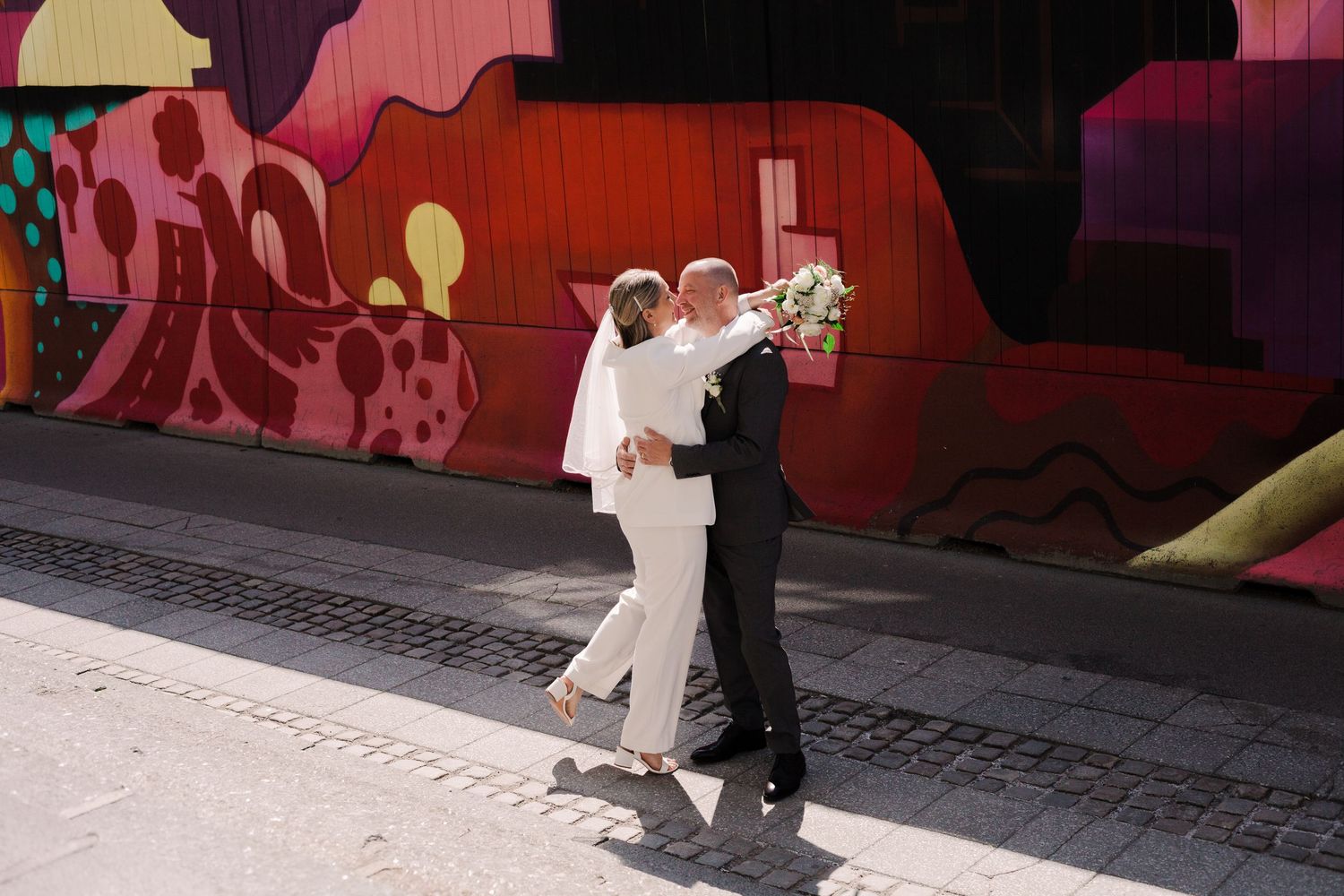 A sequence of wedding photos showing a couple walking through a red-tinted corridor.