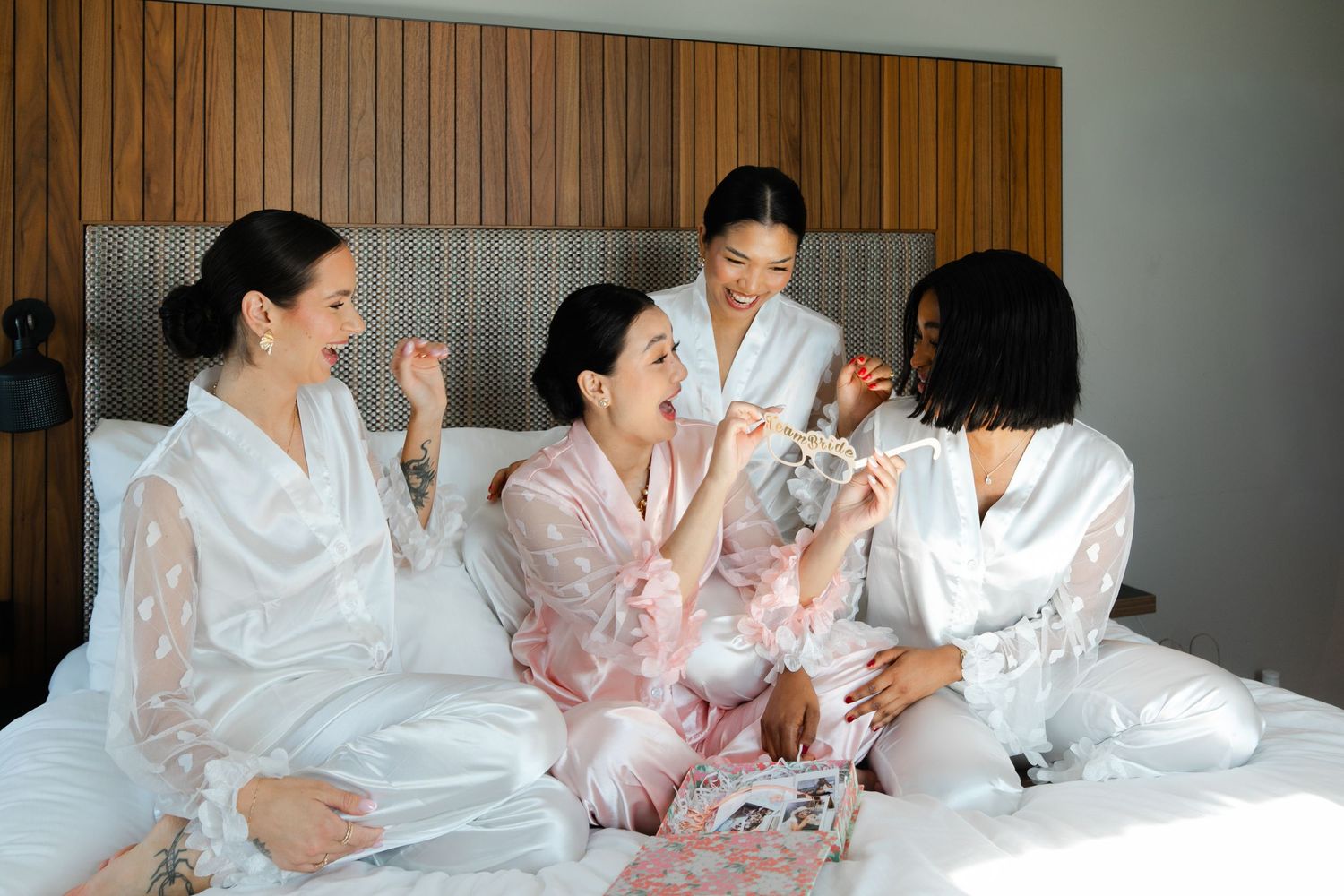 Wedding party in matching silk robes during morning preparations.