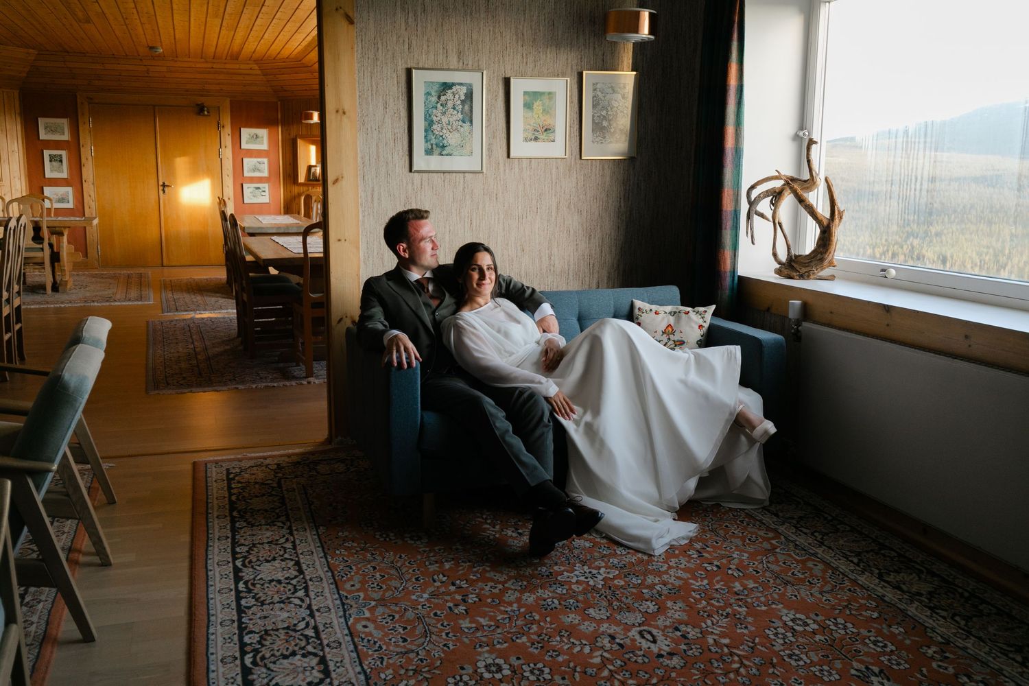 Wedding couple relaxing in a rustic room with panoramic mountain views.