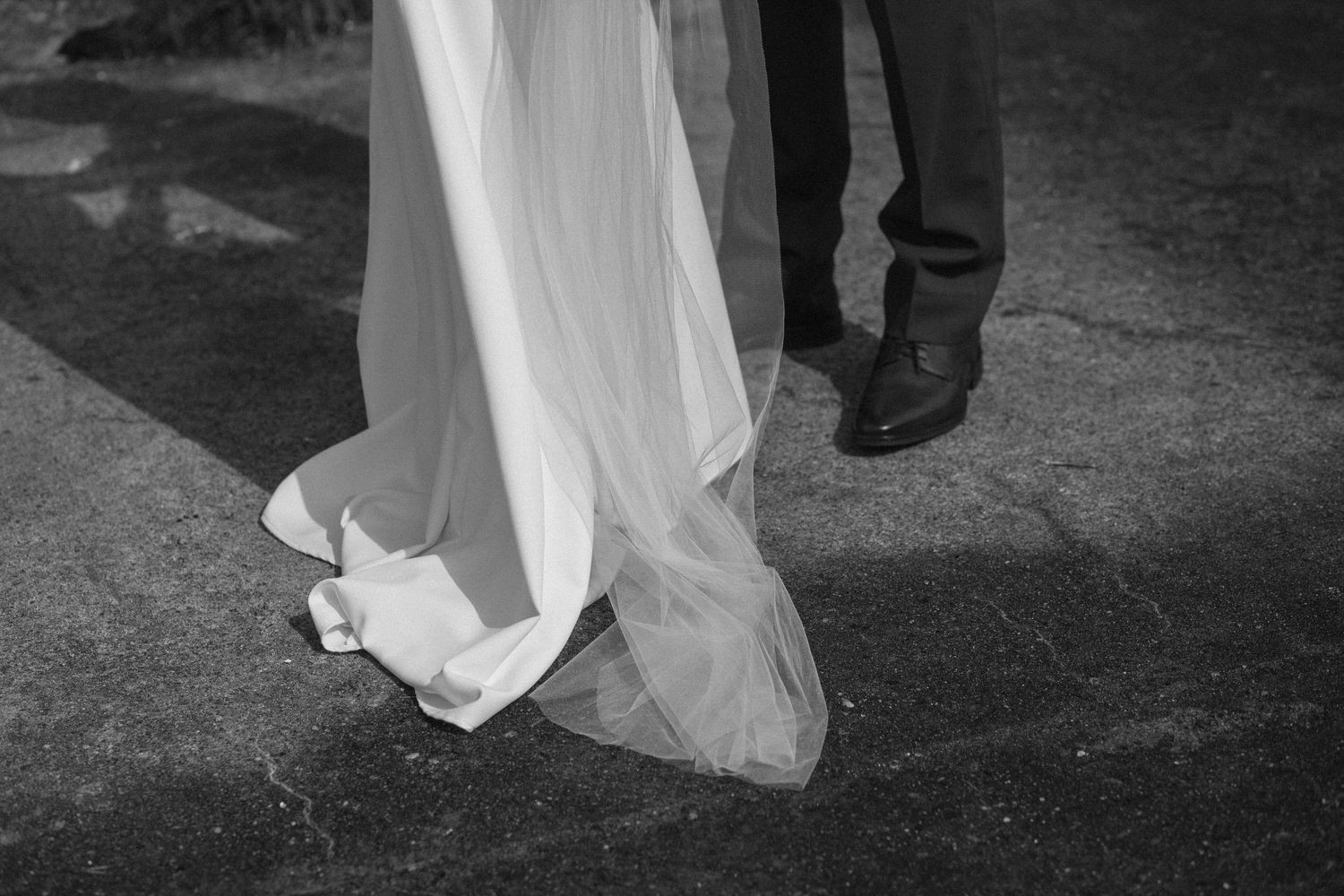 Black and white wedding portrait showing couple dancing together in an elegant setting.