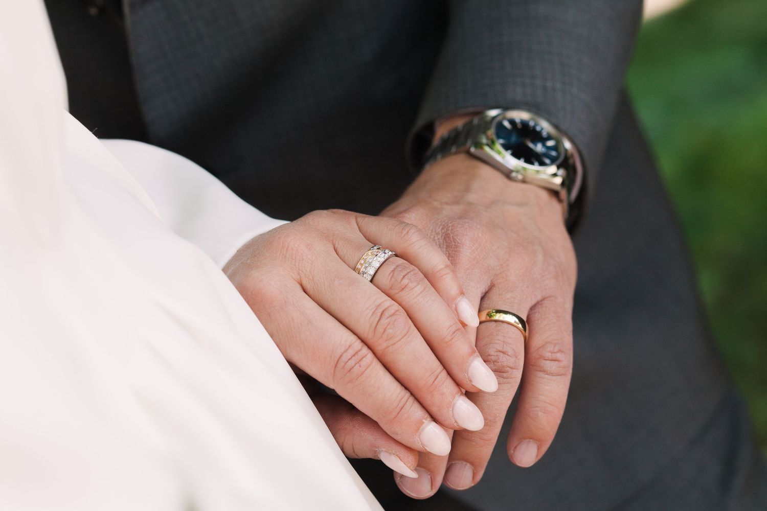 Close-up of hands wearing wedding rings during a ceremony.
