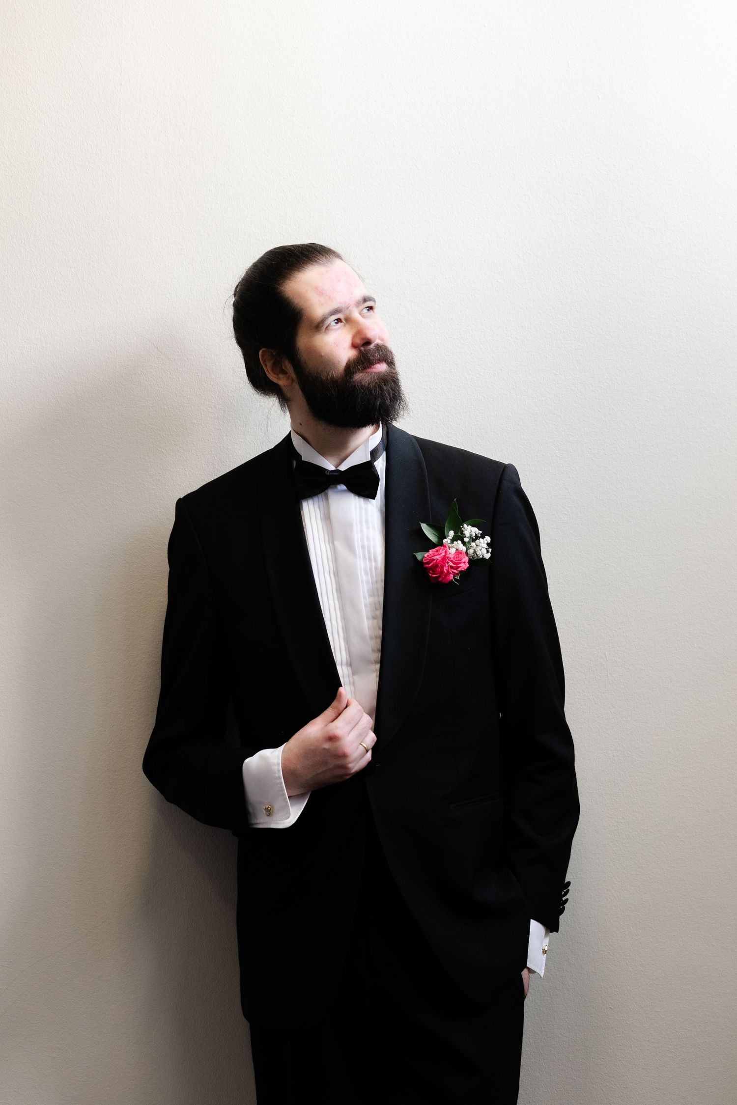 Groom in black tuxedo poses against white background in various angles.