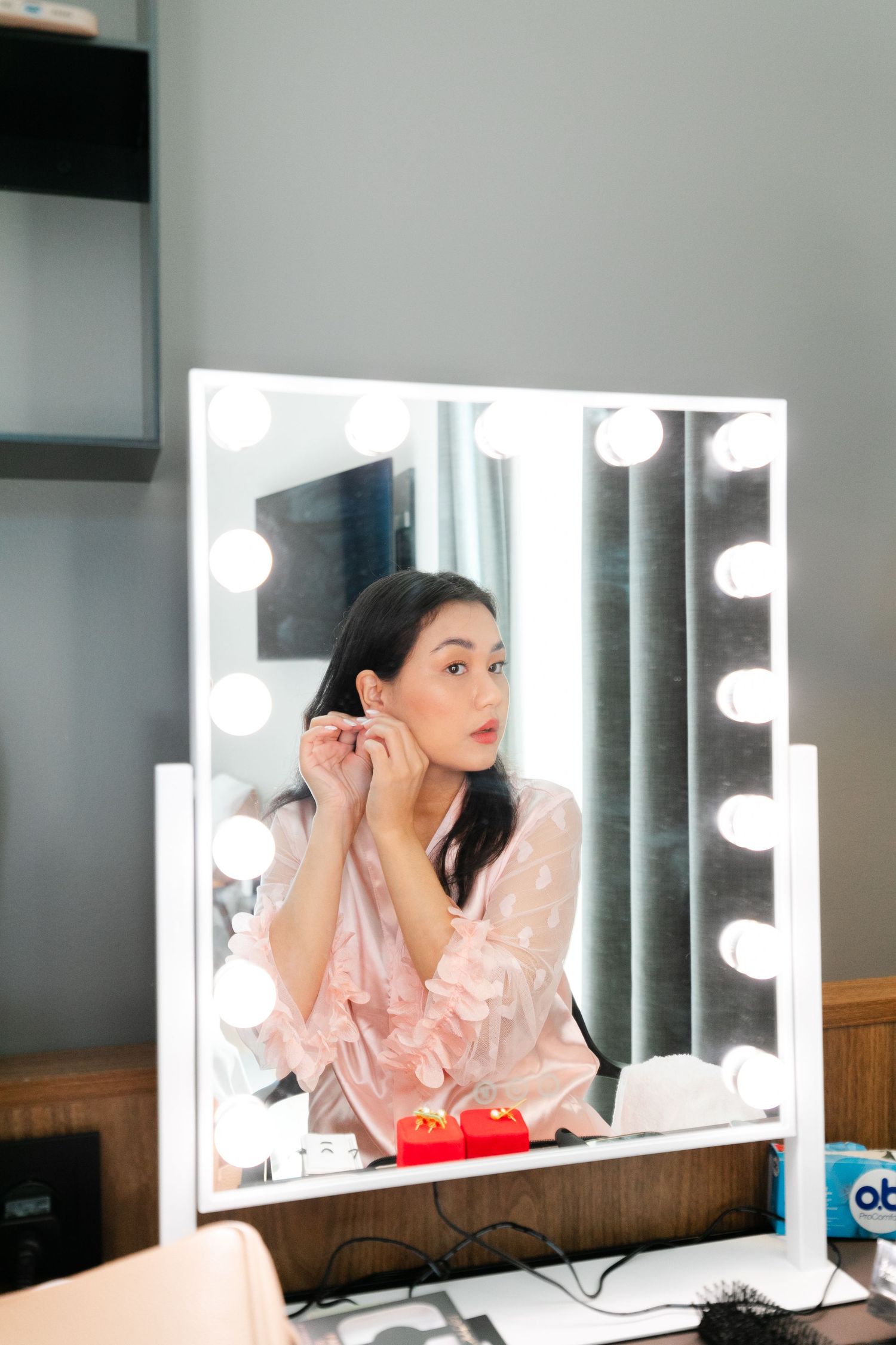 A vanity mirror setup with bright lighting for wedding day preparations.