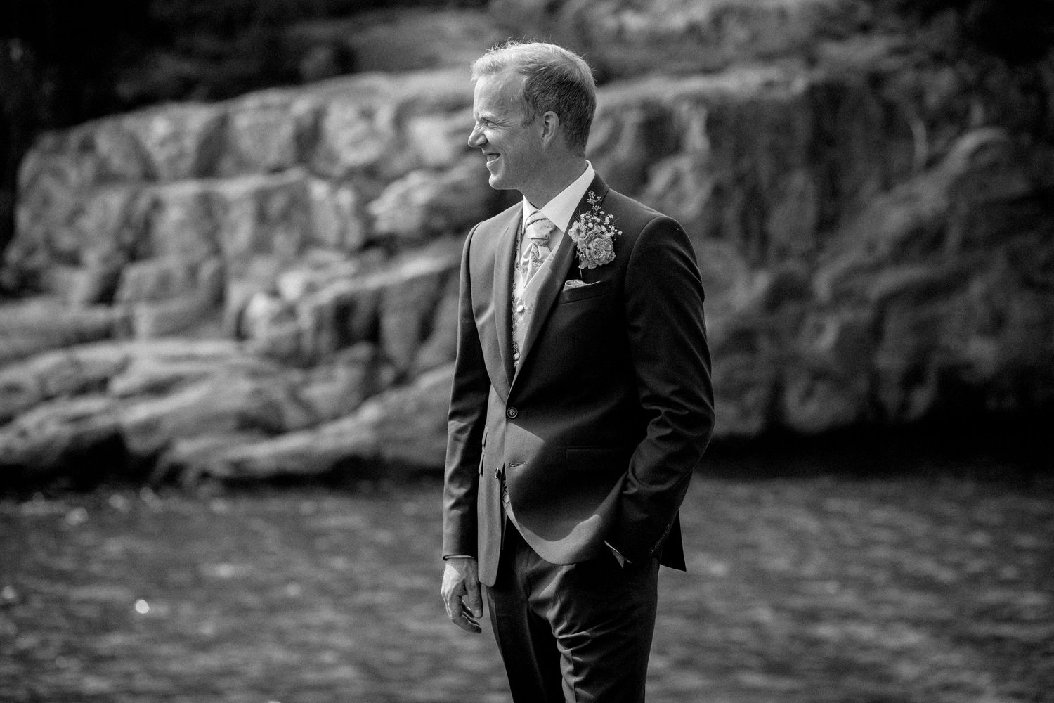 Wedding portraits in black and white against dramatic rocky backdrop.
