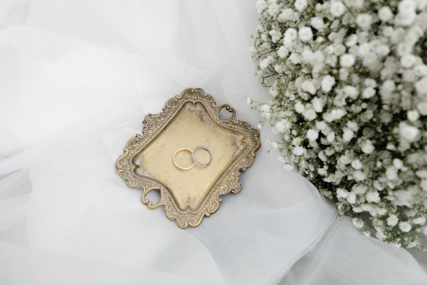 Elegant ornate vintage frame with delicate details surrounded by white baby's breath flowers.