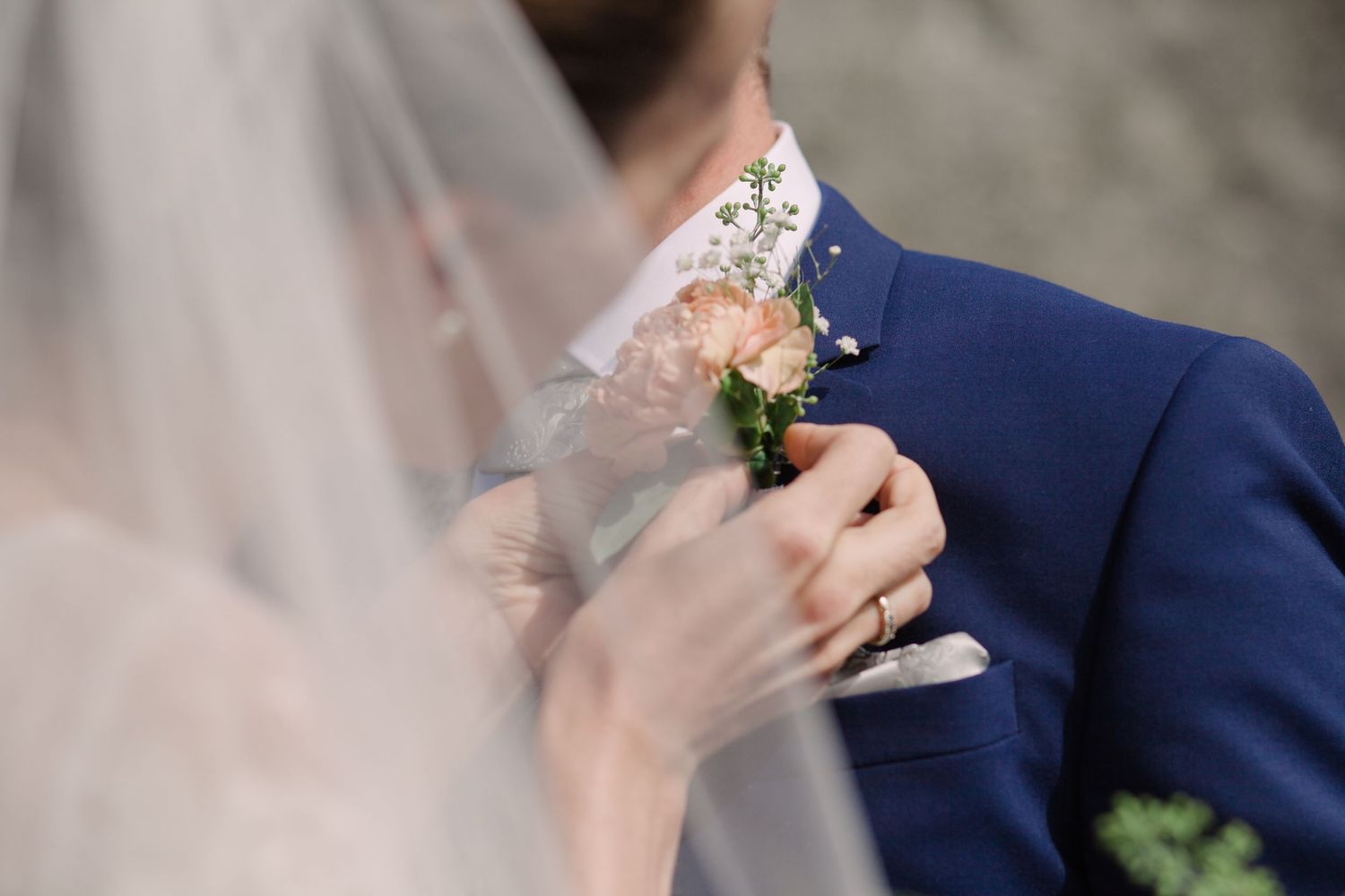 Close-up details of wedding attire and floral boutonniere.