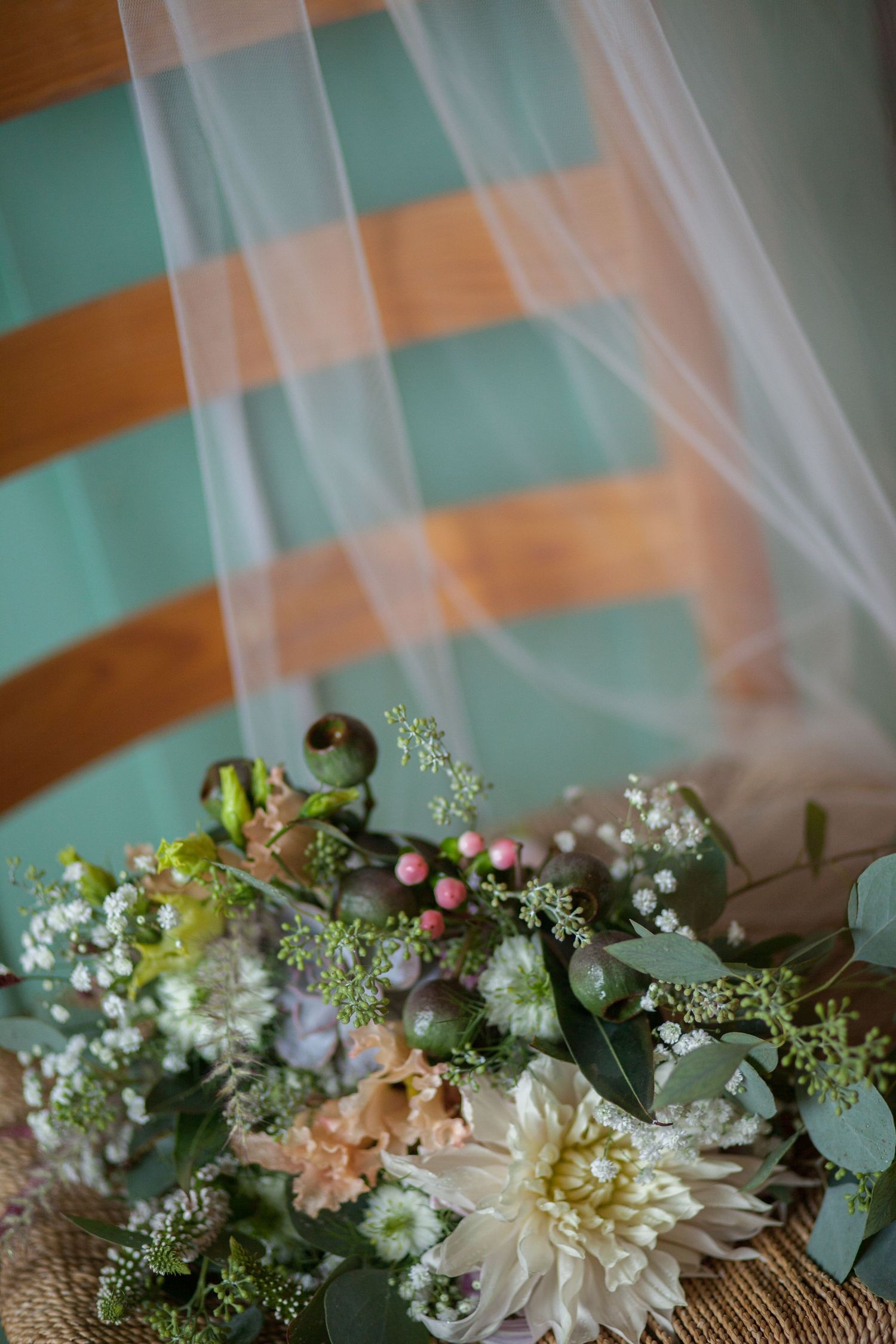 Delicate wedding floral arrangement with white dahlias and greenery.