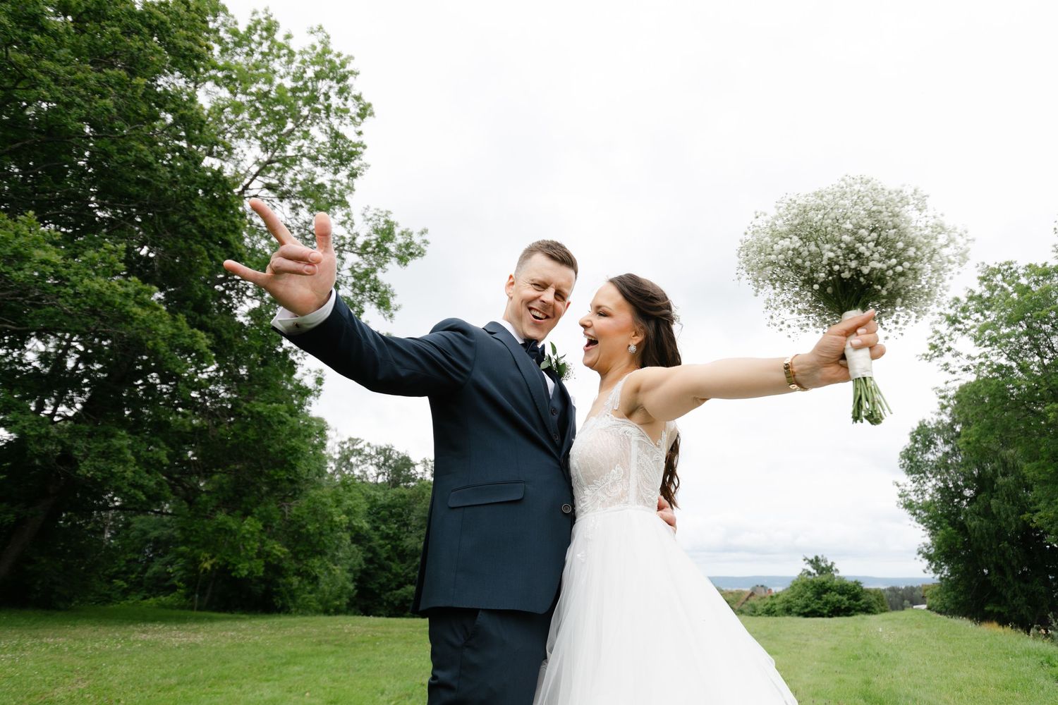 Wedding couple walking and dancing through a lush green garden path on their special day.