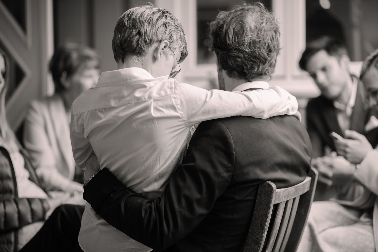 Black and white images showing intimate moments at an indoor wedding celebration.