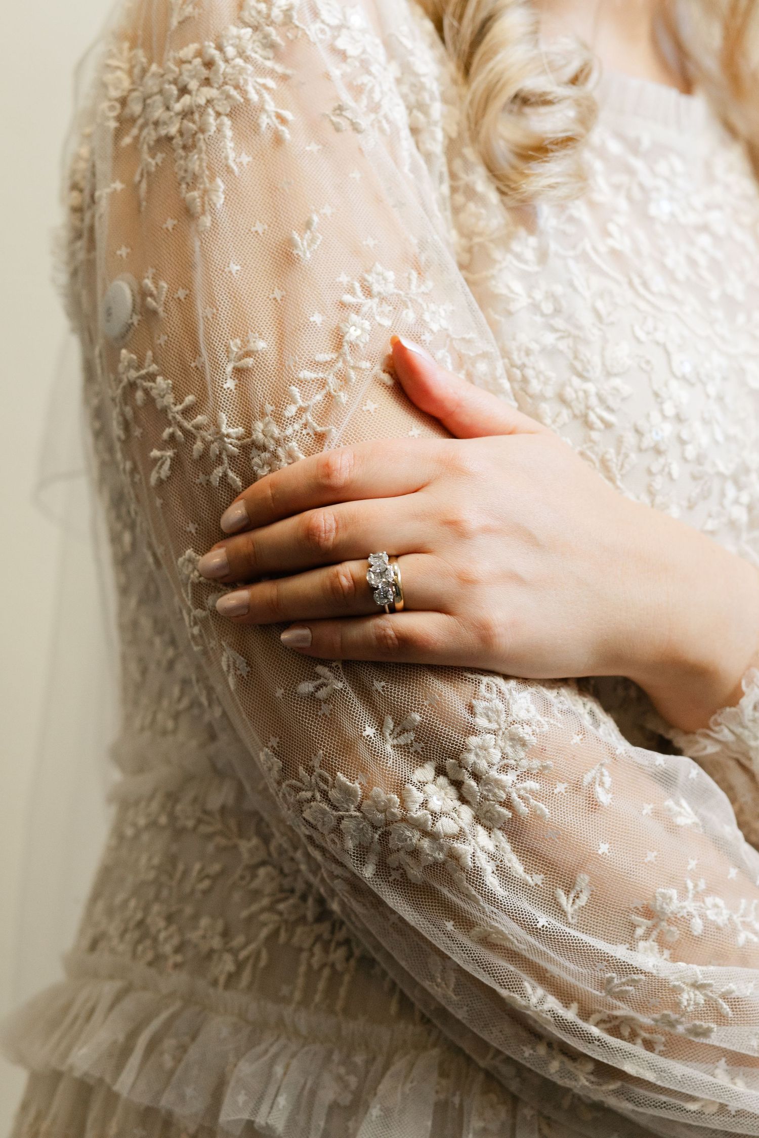 Close-up details of intricate lace and beadwork on a wedding dress.