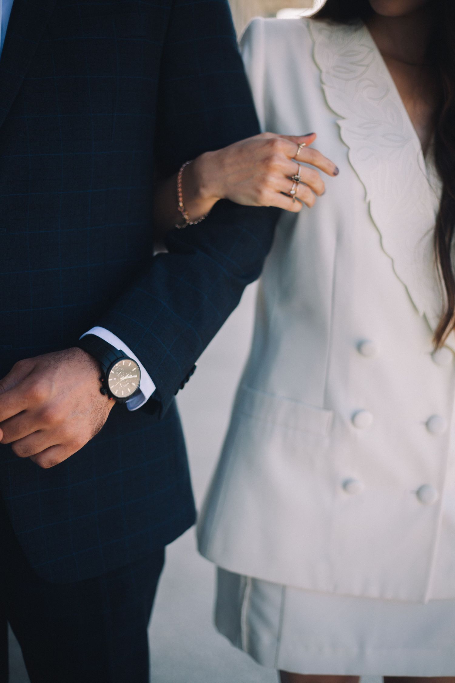 Close-up details of formal attire and hands in elegant lighting.