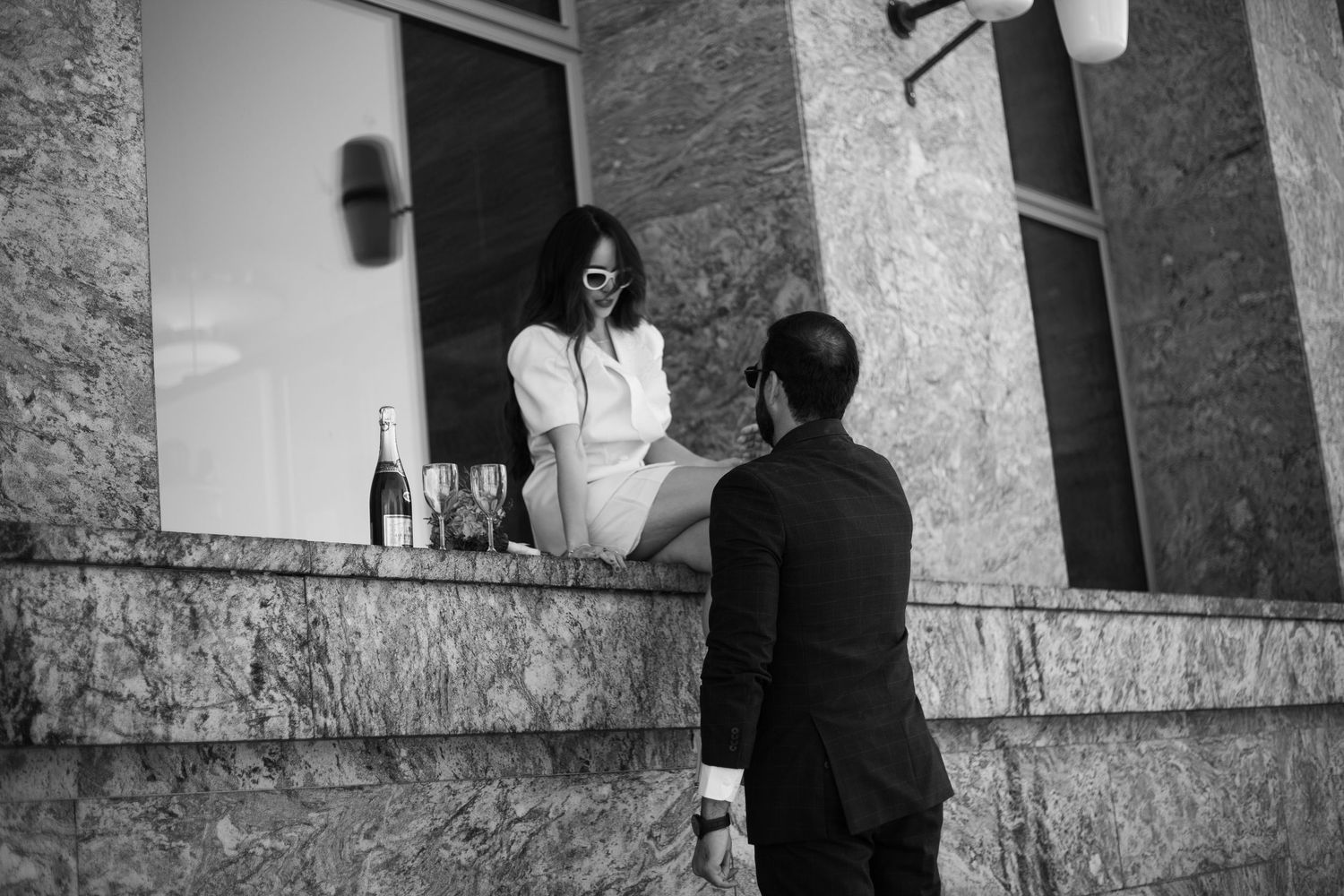 Artistic black and white shots of a couple sitting on stone steps.