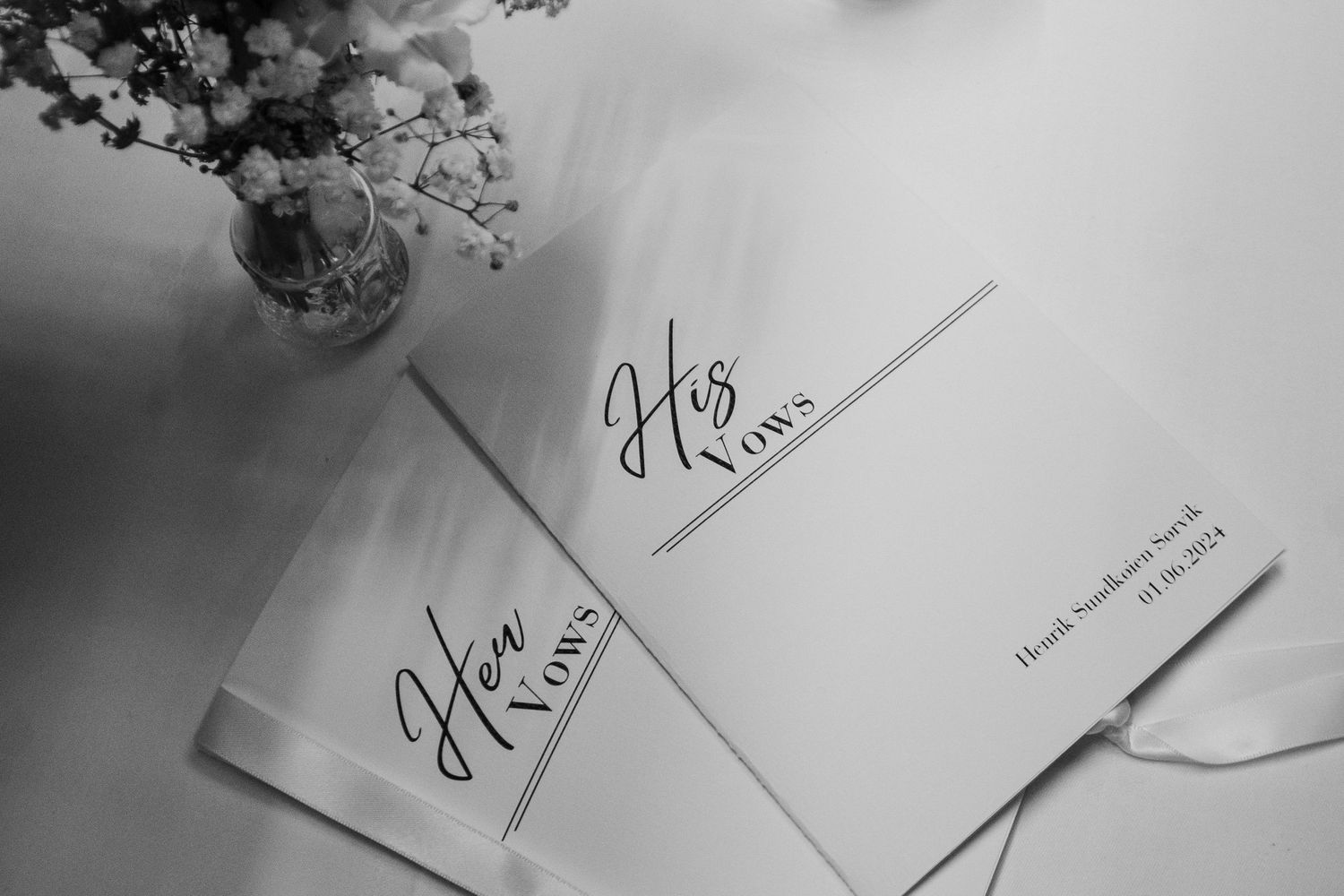 Close-up of handwritten signatures on paper documents in monochrome.