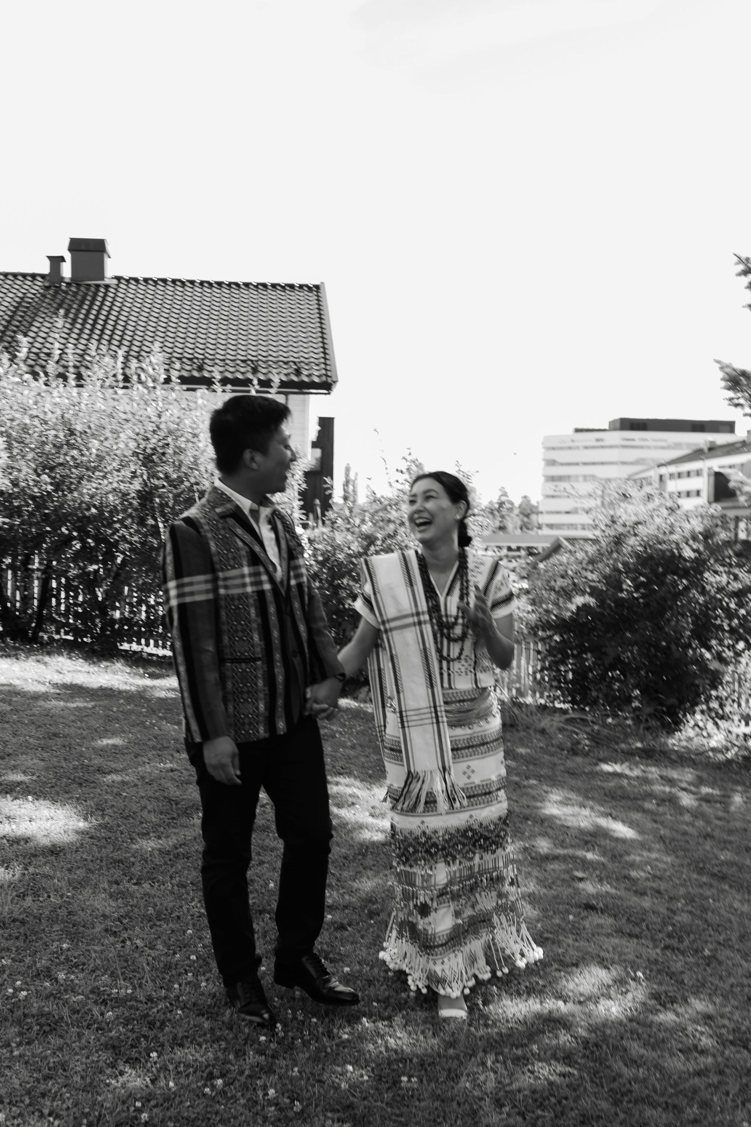 Black and white candid shots of a couple playfully interacting in a garden setting.