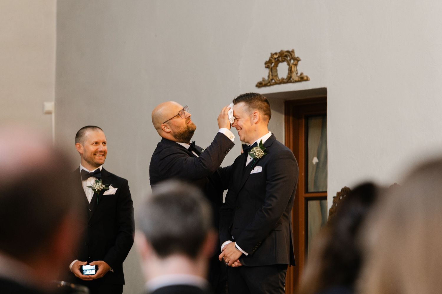 Wedding party members sharing joyful moments in formal attire.
