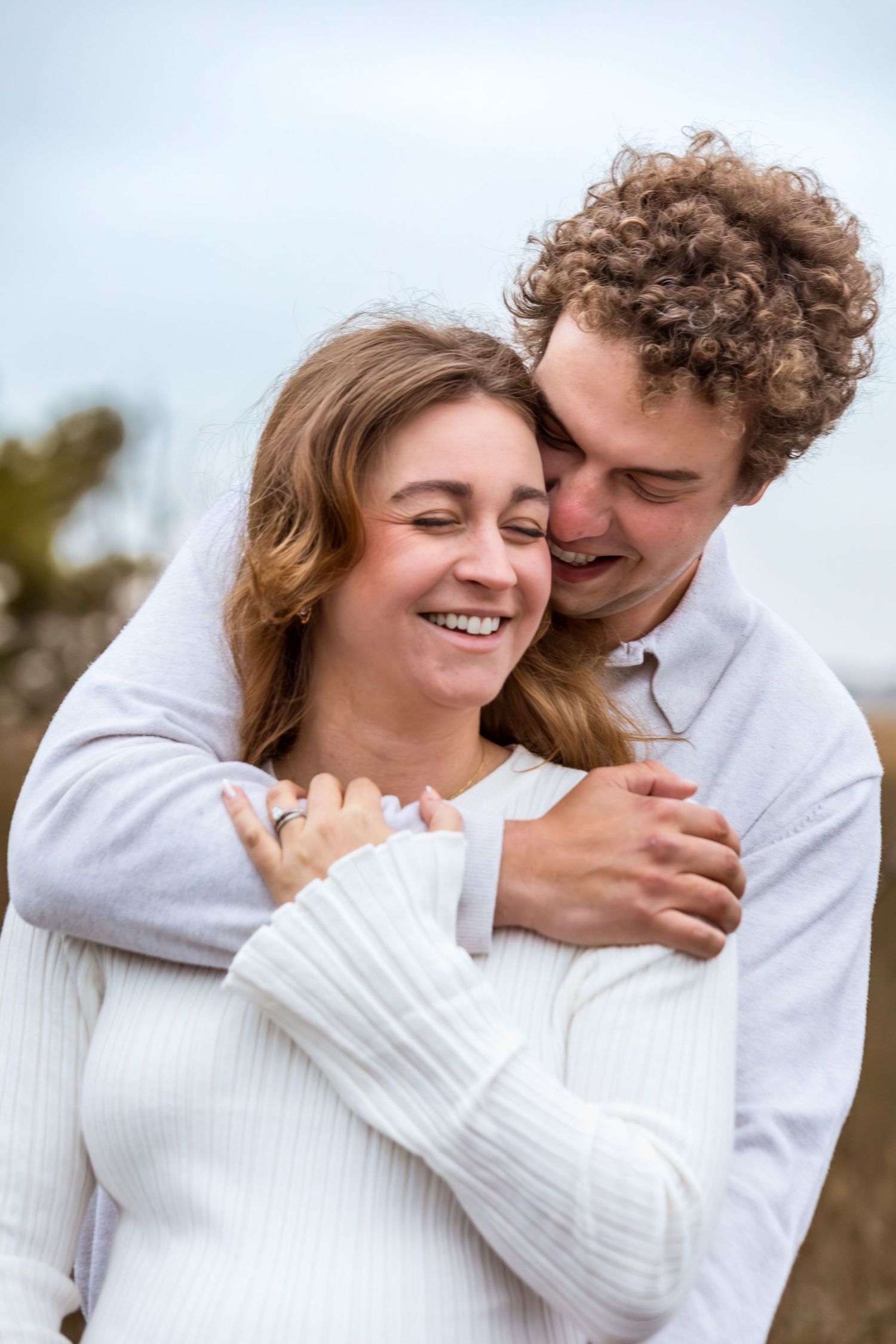 Couple in white sweaters sharing intimate romantic moments outdoors in a series of candid photos.