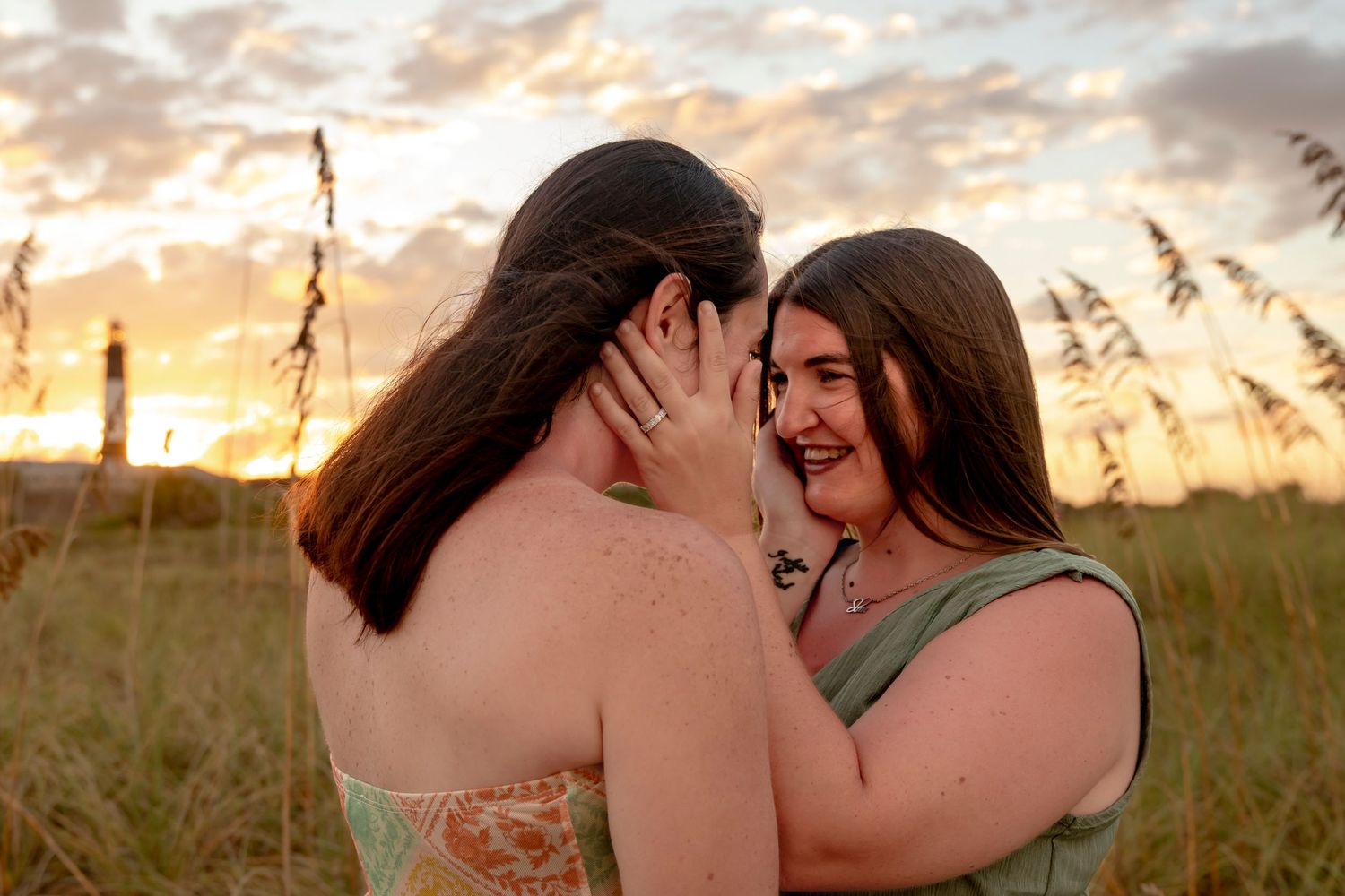 Romantic sunset silhouette with sea oats in the foreground.