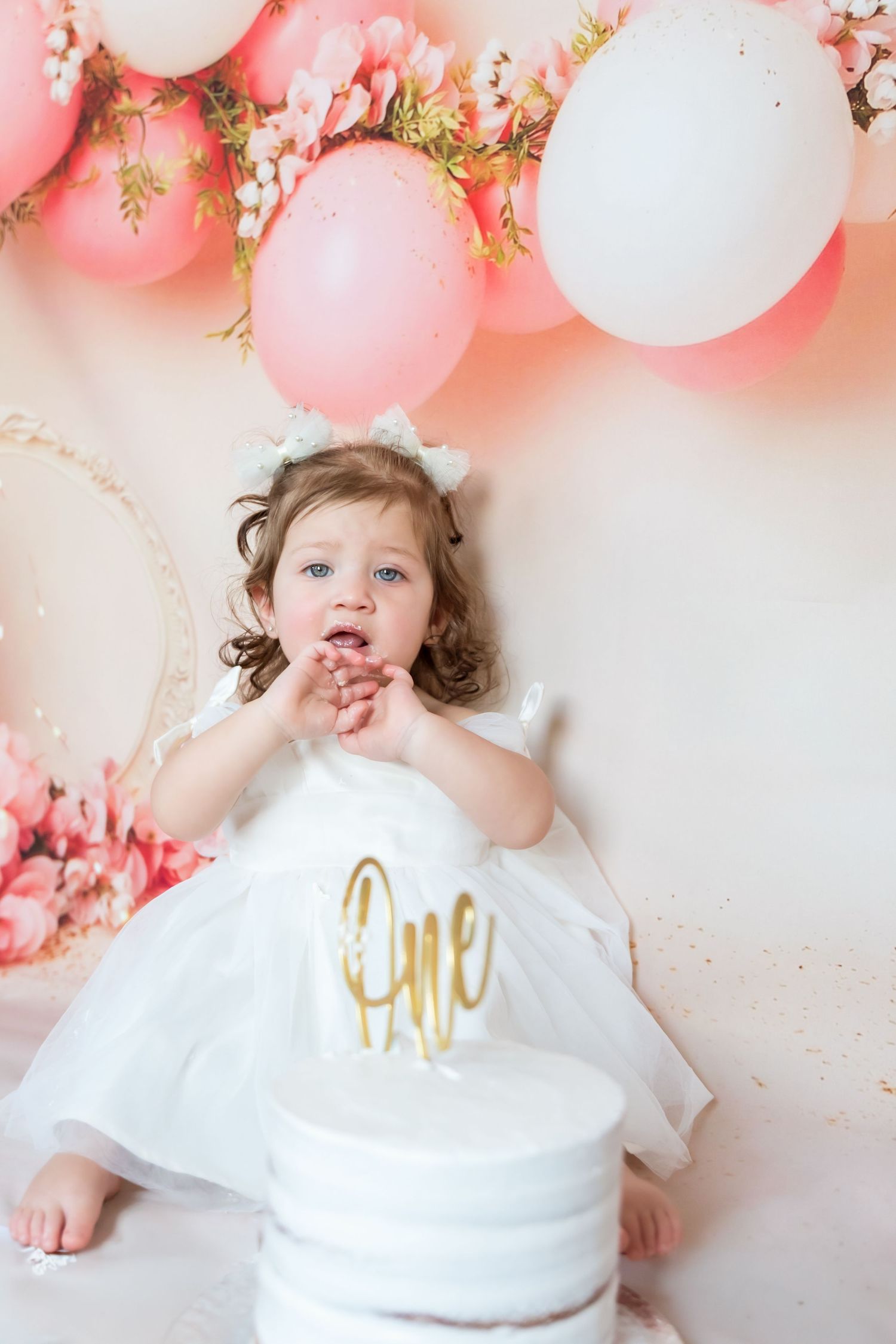 A series of pink and white balloon decorations frame a sweet birthday celebration scene against a light background.