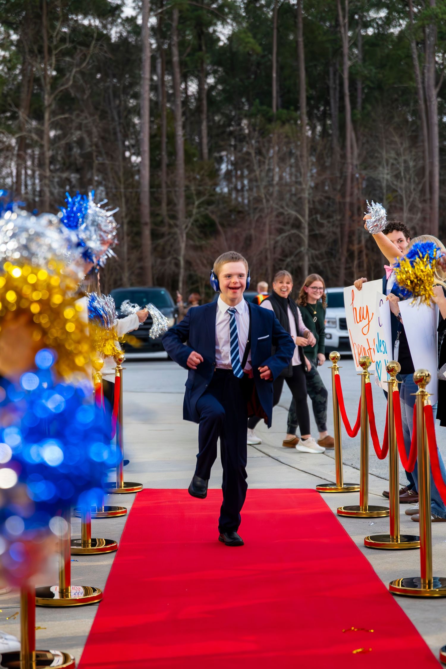 Red carpet event entrance with blue and gold balloon decorations and stanchion posts.