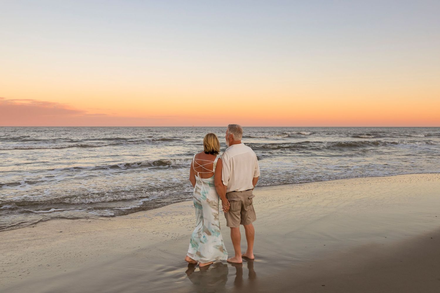Romantic beach photoshoot at sunset with couples walking along shoreline.