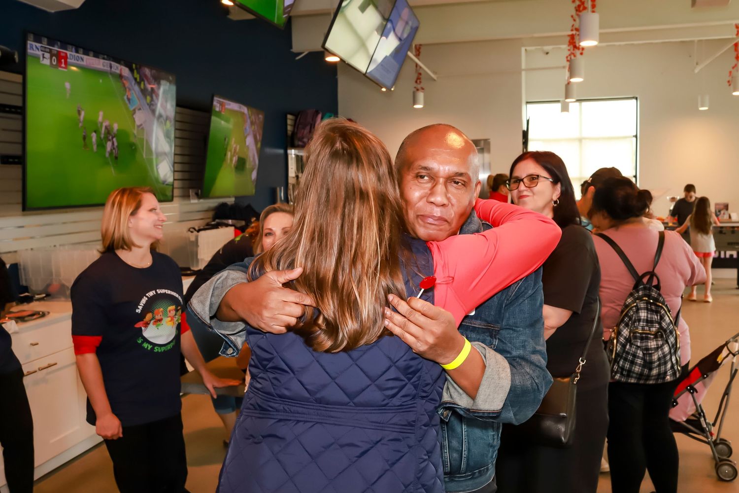 People gathered in an indoor space for a social event with blurred background.