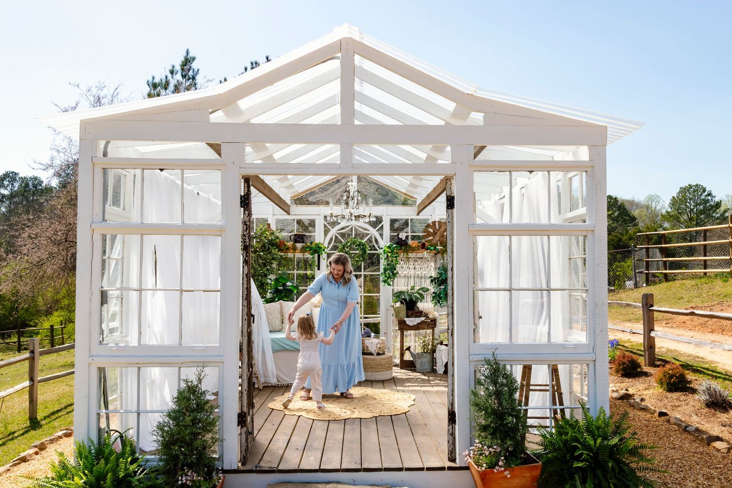 A series of photos showing the construction stages of a white wooden greenhouse or garden structure with glass panels.