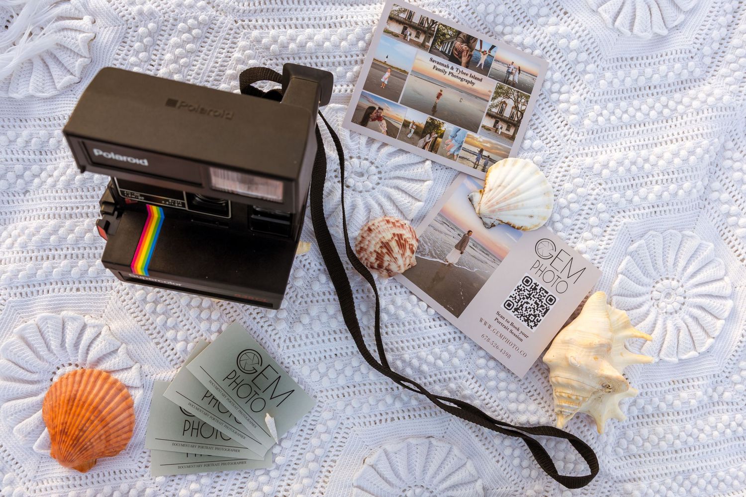 Vintage Polaroid camera collection displayed on white lace doily with various film accessories and photographs.