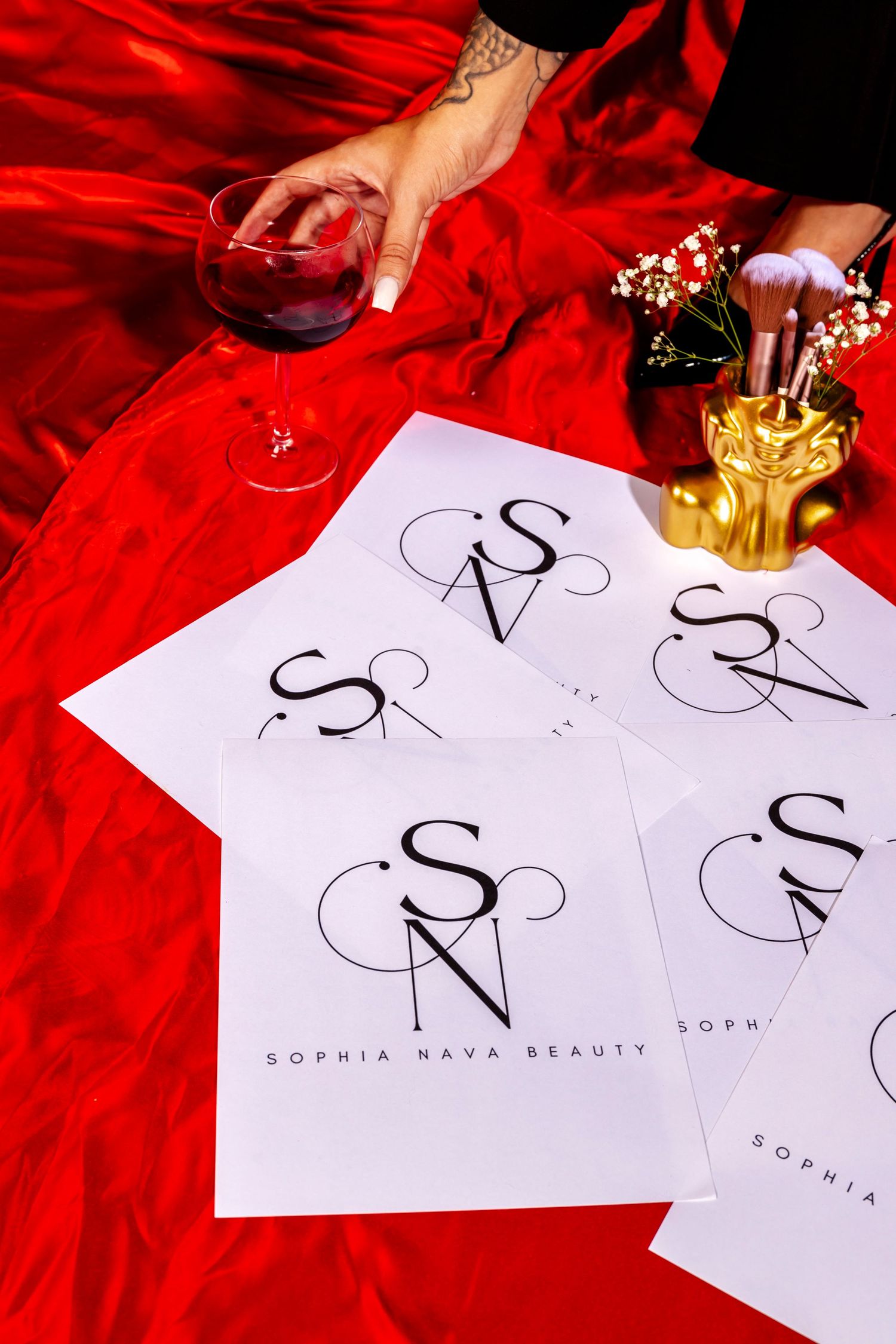 Marketing materials for Sophia Nava Beauty with wine glass on red velvet fabric.