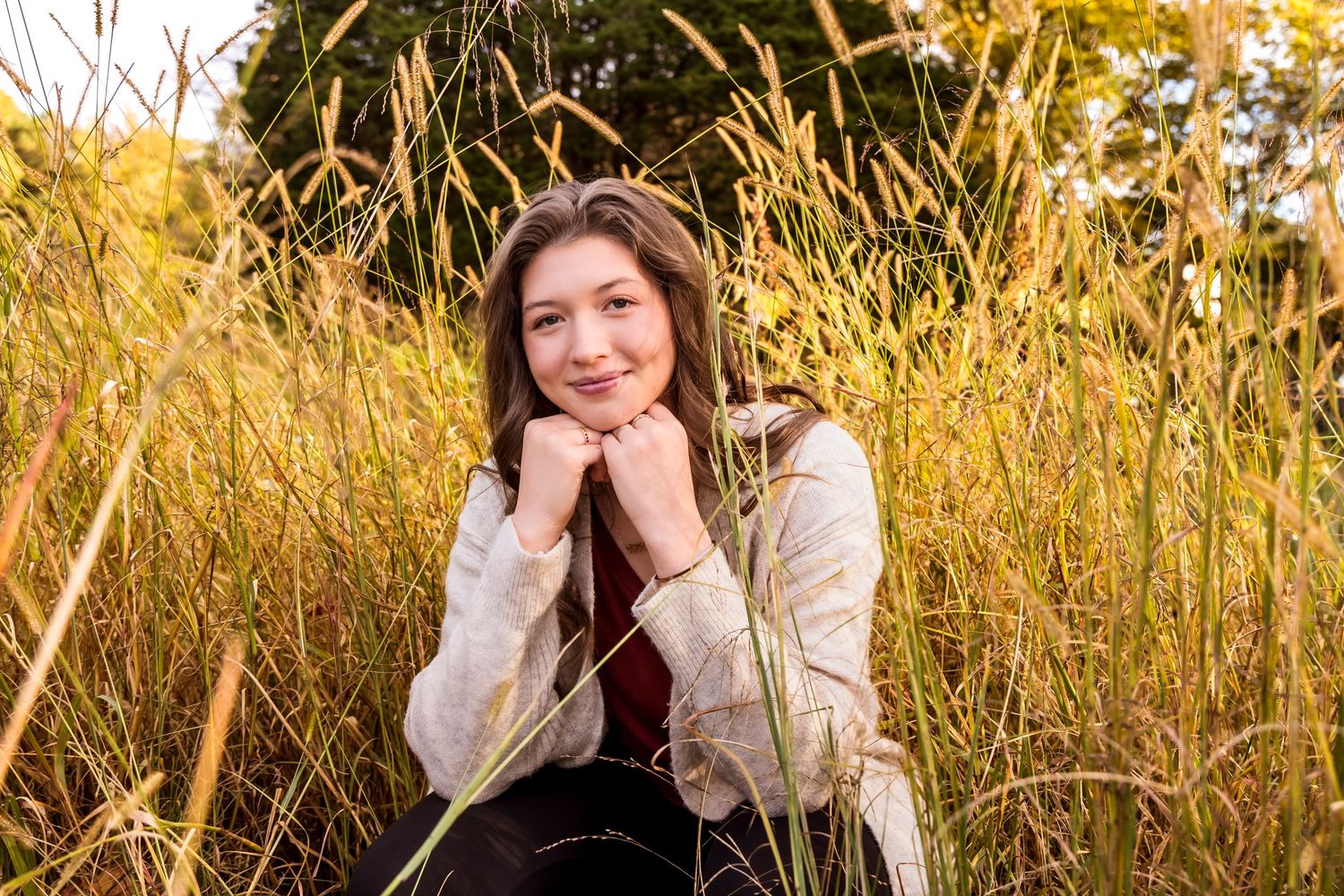 Portrait session in tall golden grass during sunset.