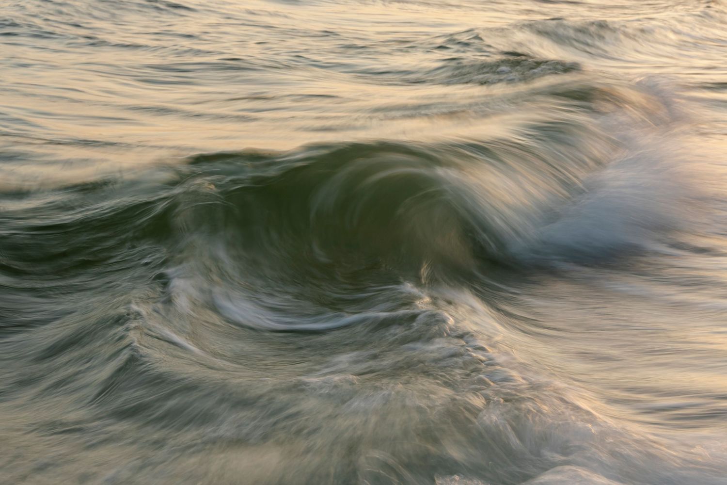 Dynamic ocean wave patterns captured in soft evening light.