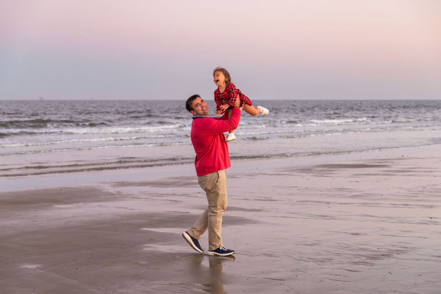 Playful beach photoshoot sequence at sunset with red and khaki outfits.