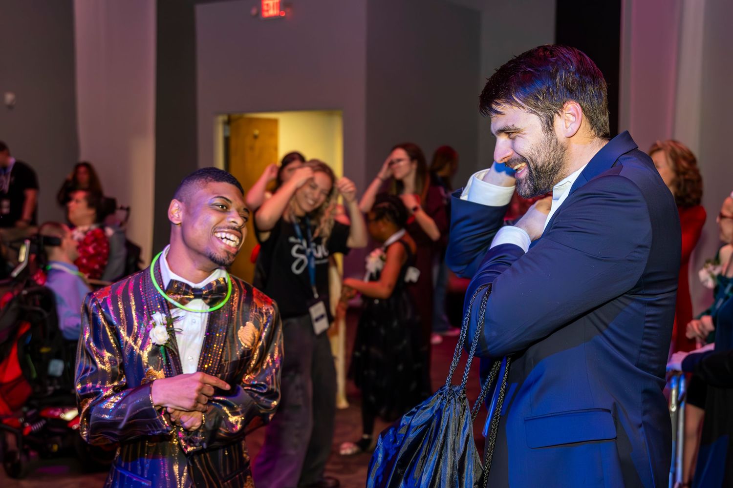 Two performers entertaining guests at a lively indoor reception event.
